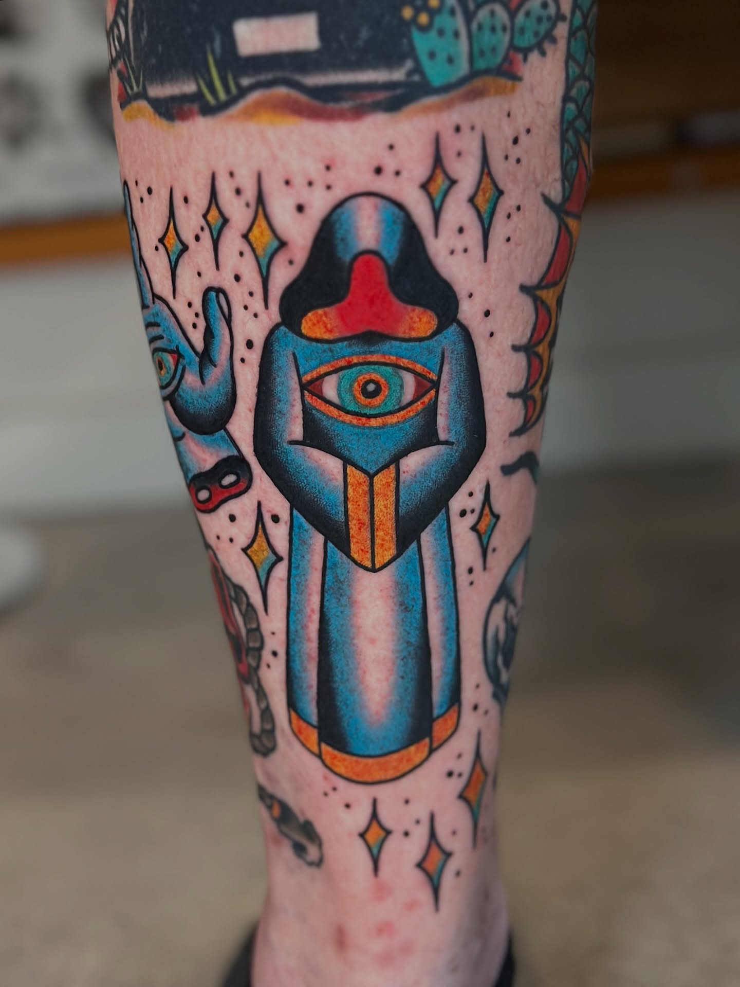 Eye and mask American traditional tattoo on the leg by Michael Williams