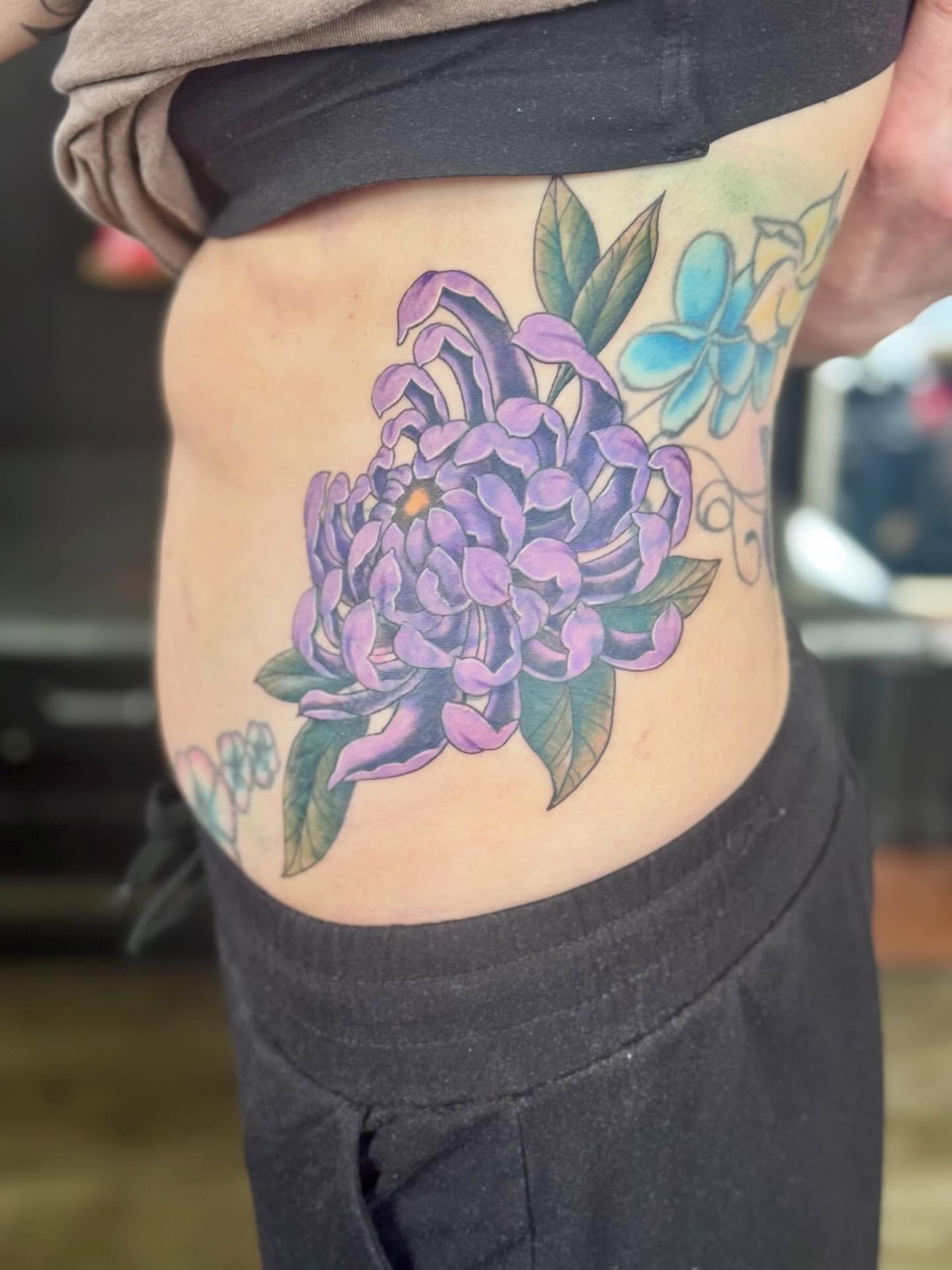 Purple flower dotwork tattoo on the ribs by @carissaetattoos