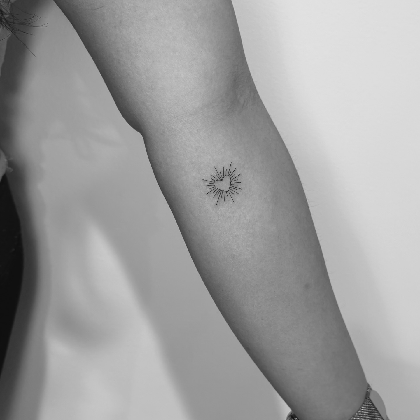 Heart with rays fine line tattoo on the forearm by Jessica, Cheektowaga, New York