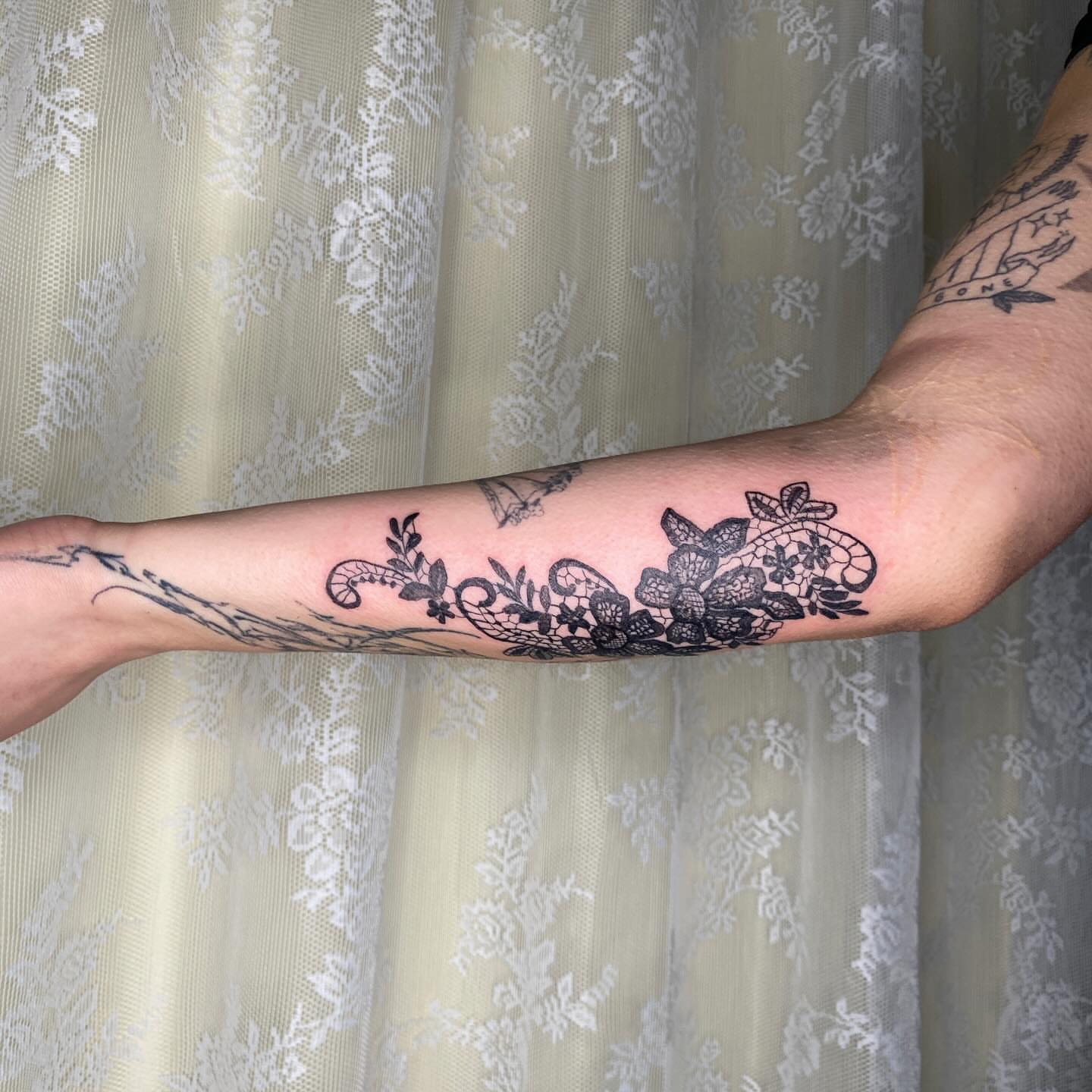 Lace and floral black and grey tattoo on the forearm by °₊⊹ delia ✩ jane ೃ࿔*