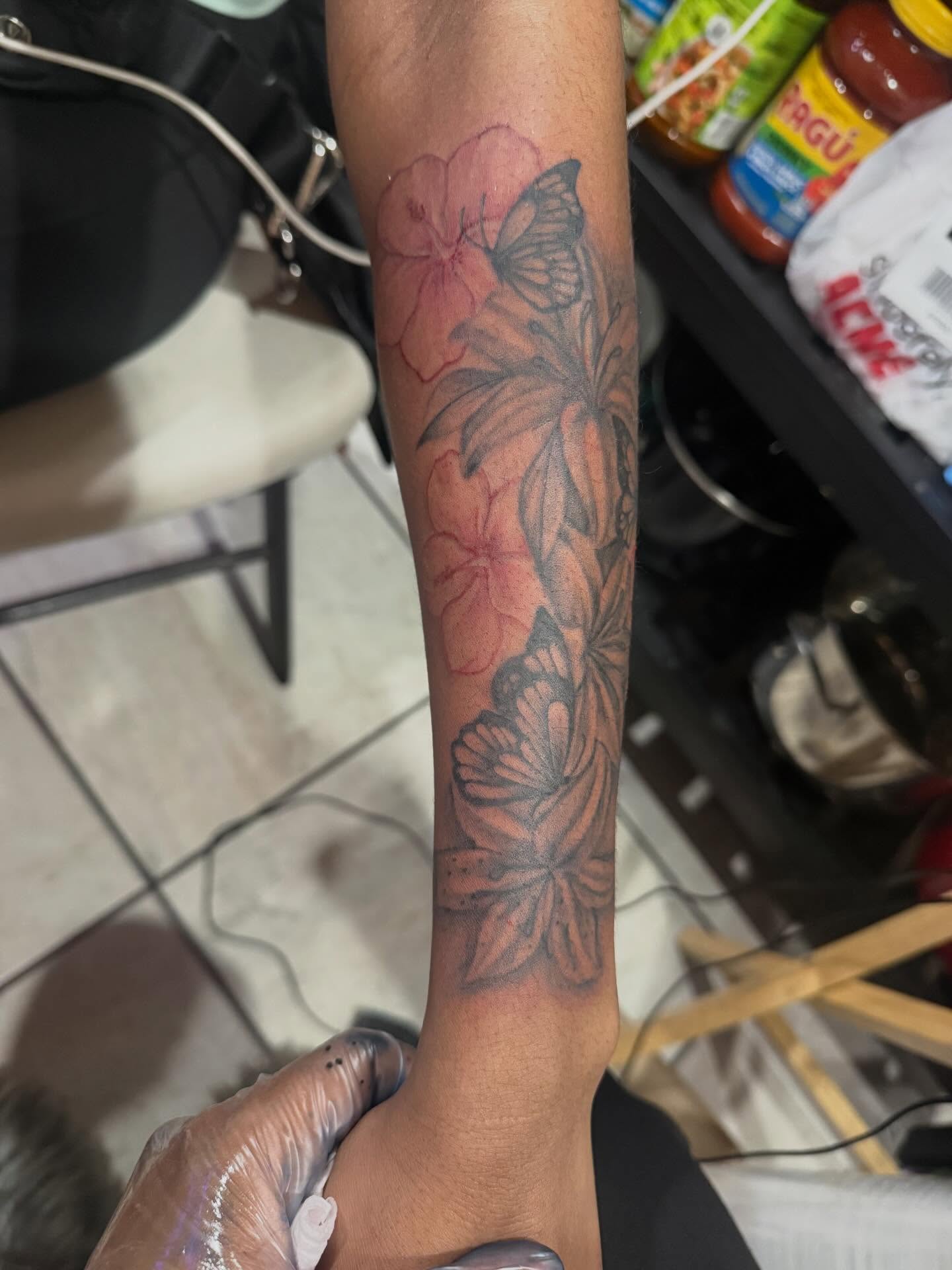 Flowers and butterflies black and grey tattoo on the forearm by Aja Marie