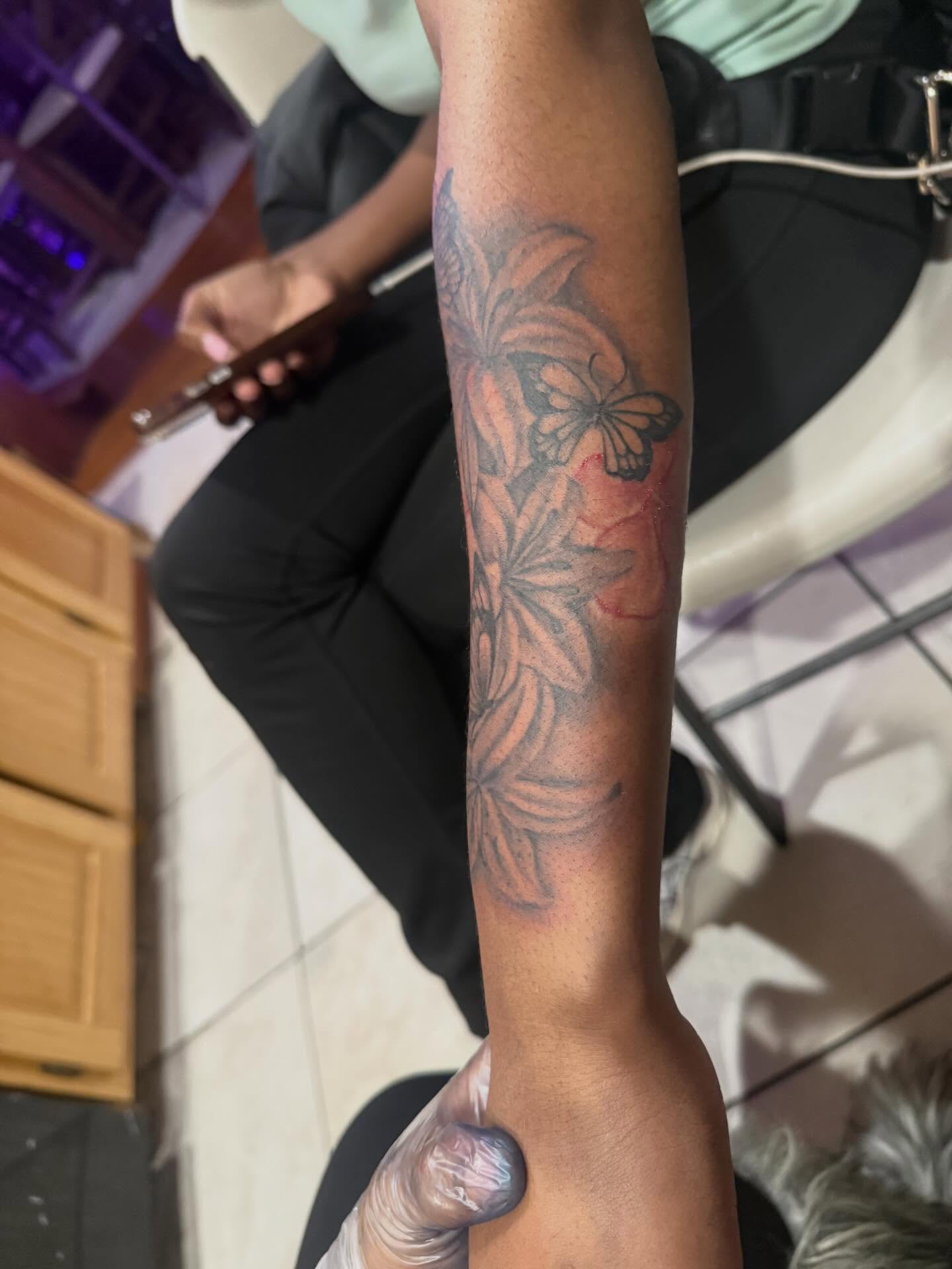 Butterfly and leaves black and grey tattoo on the forearm by Aja Marie