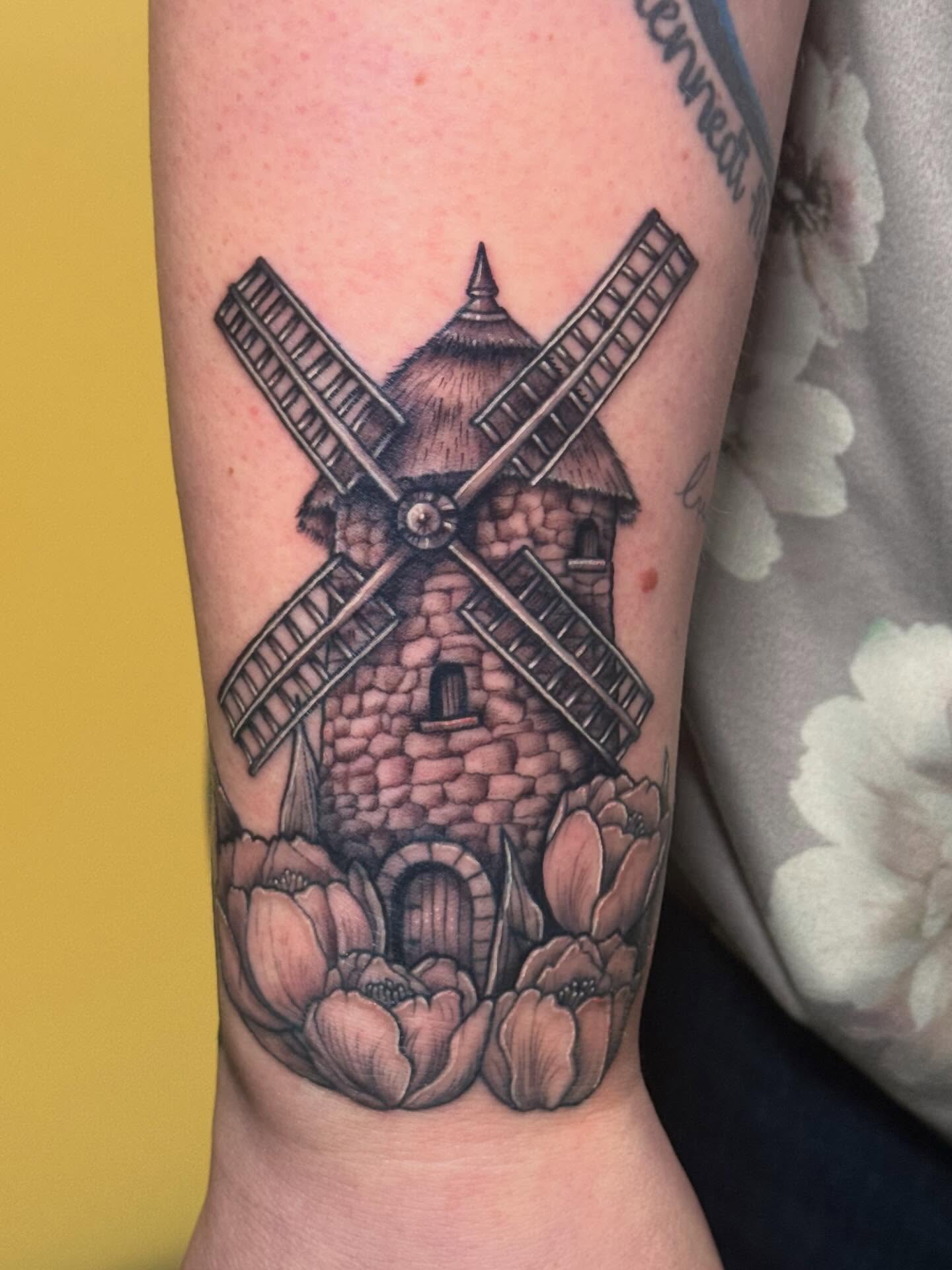Windmill black and grey tattoo on the forearm by Madison Pegram