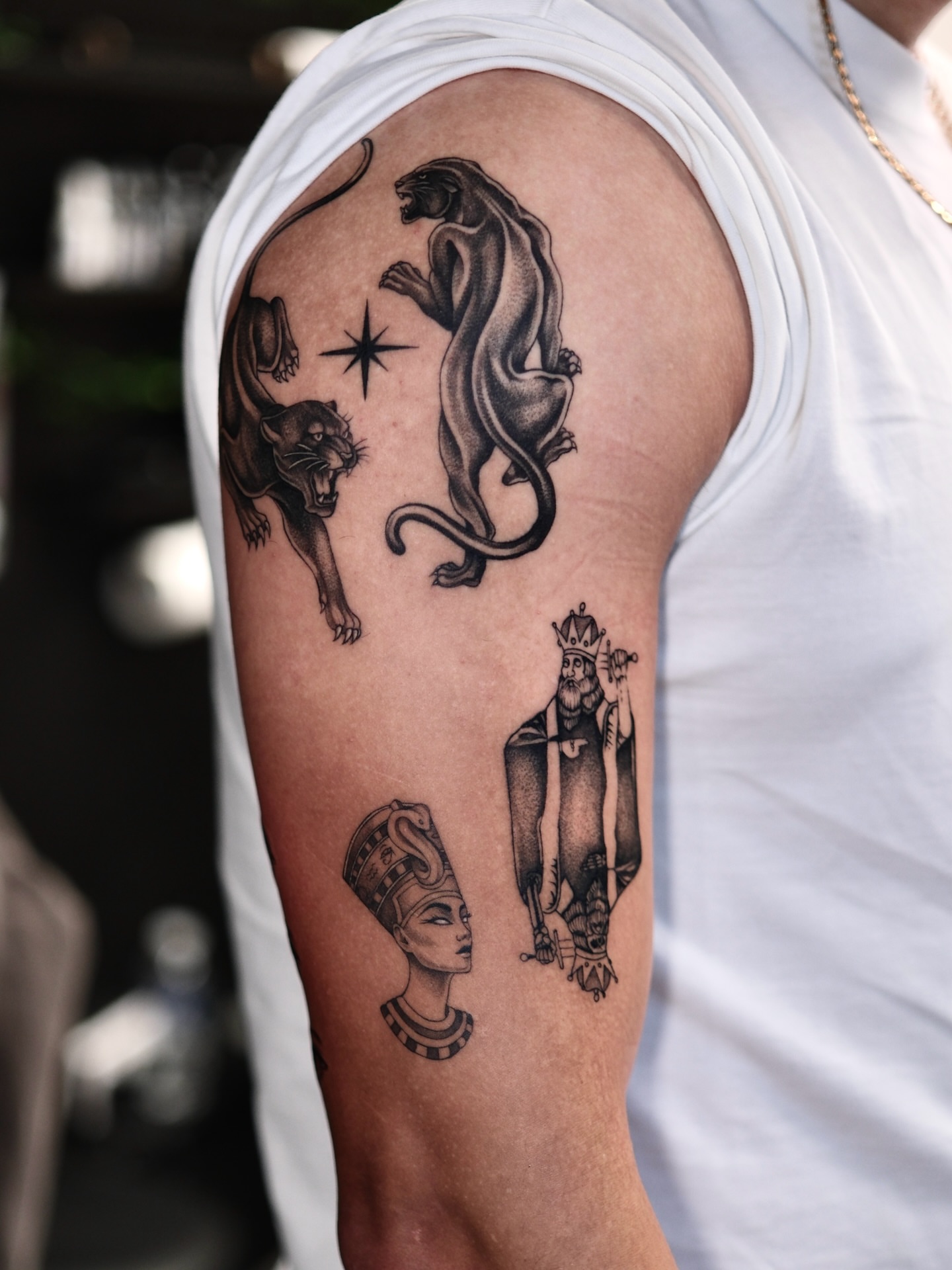 Panthers and pharaoh black and grey tattoo on the upper arm by IVY
