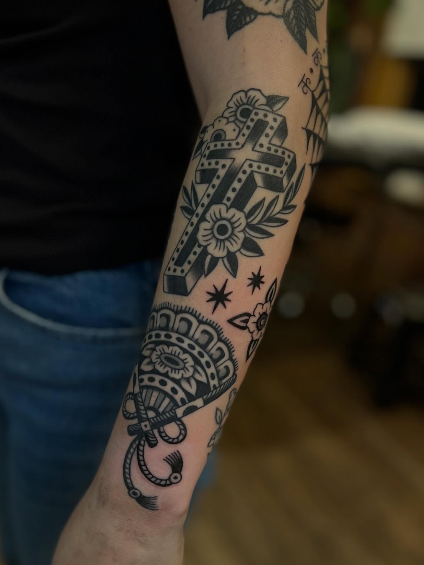 Cross and floral American traditional tattoo on the forearm by Syd Sayyah