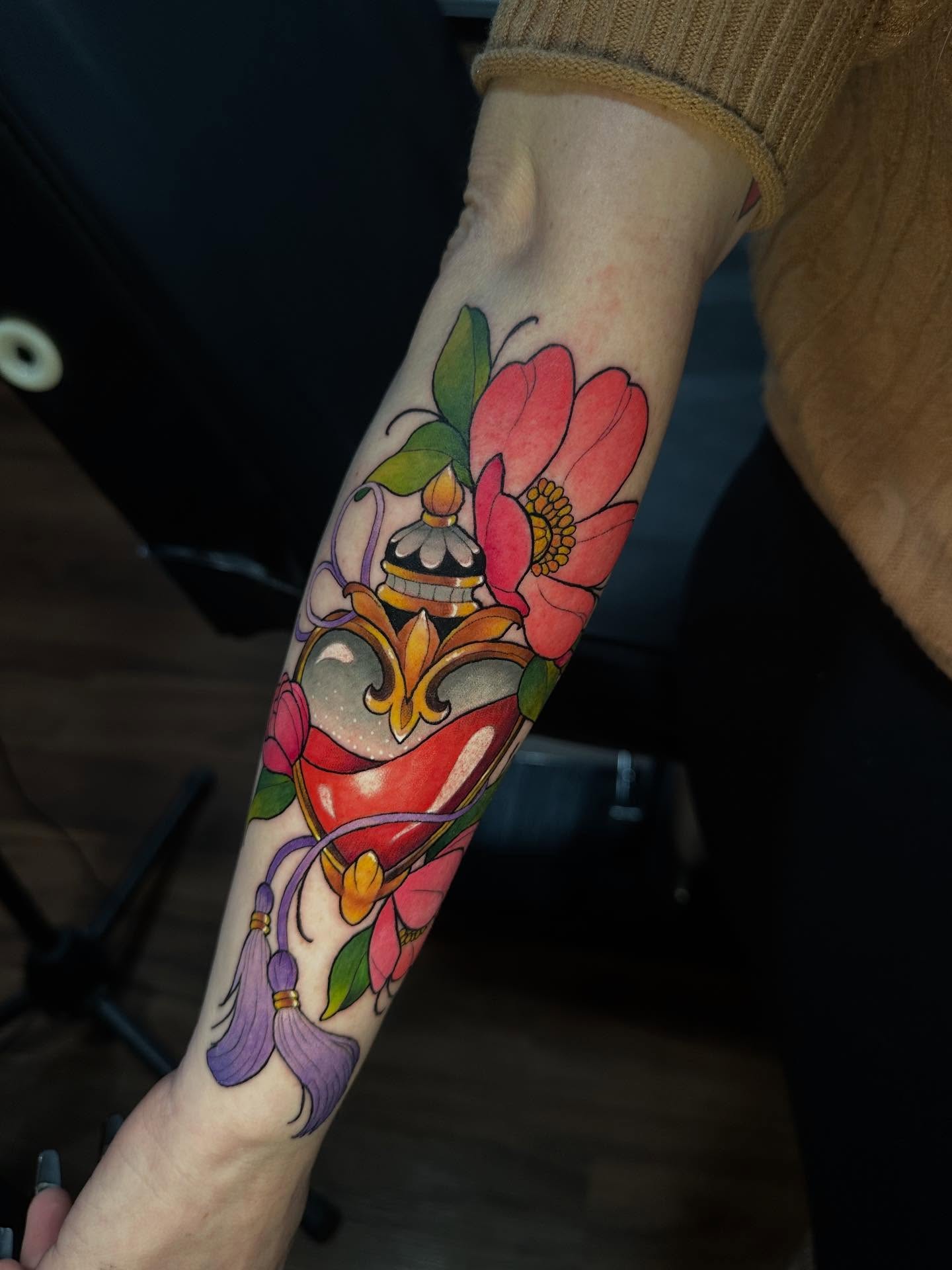 Heart with flowers American traditional tattoo on the forearm by Mario Flores Tattoo