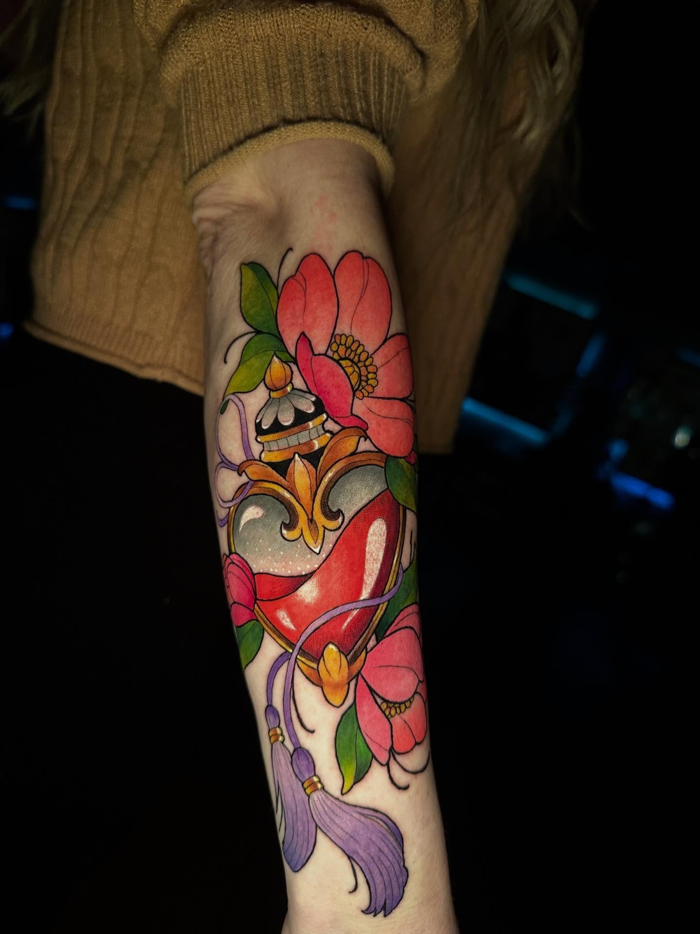 Heart with flowers American traditional tattoo on the forearm by Mario Flores Tattoo