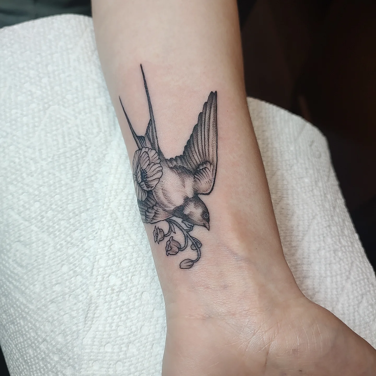 Swallow and flower realism tattoo on the forearm by Jennifer Fowler