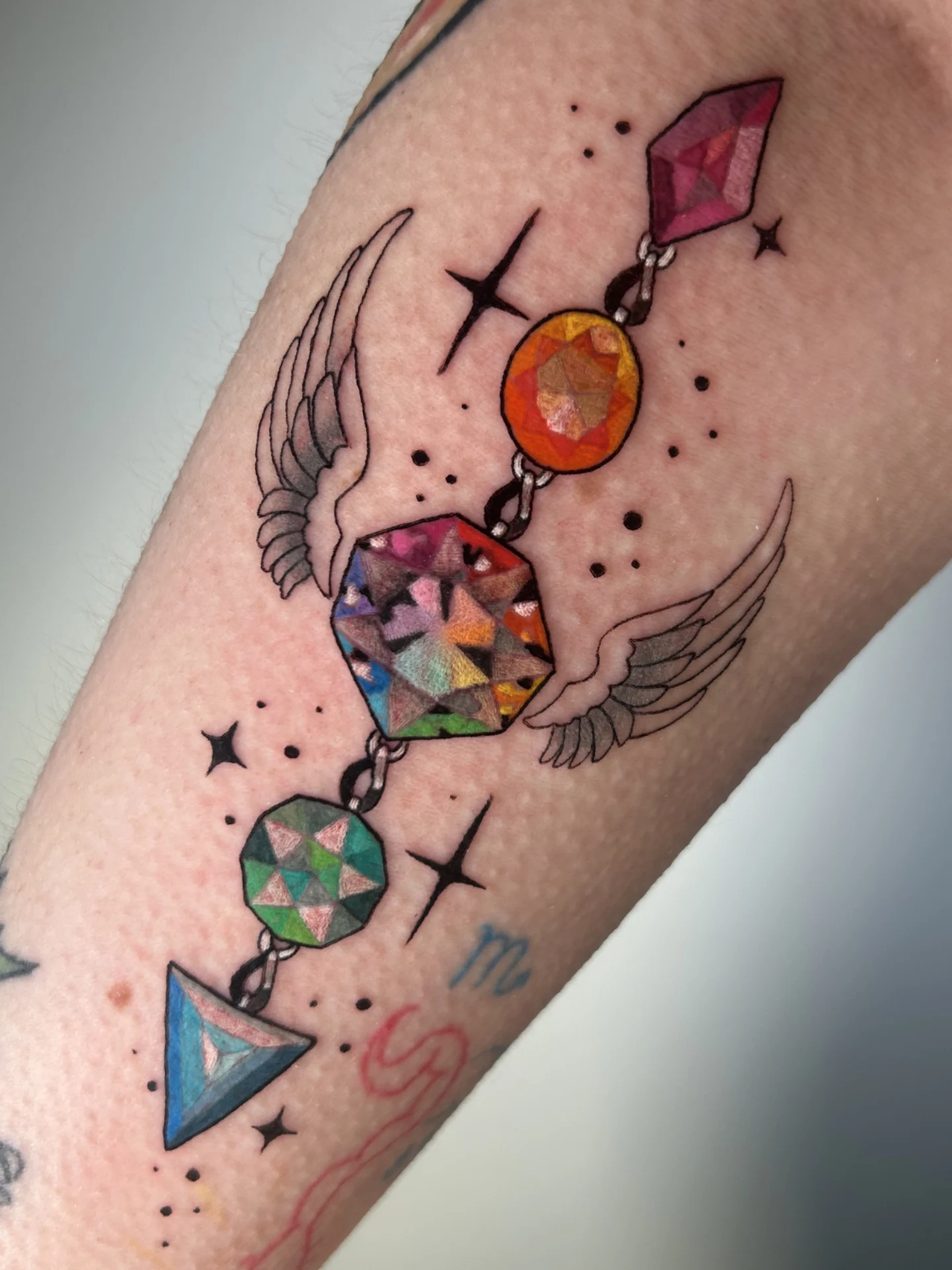 Gemstones and celestial symbols geometric tattoo on the forearm by Chloe Marie