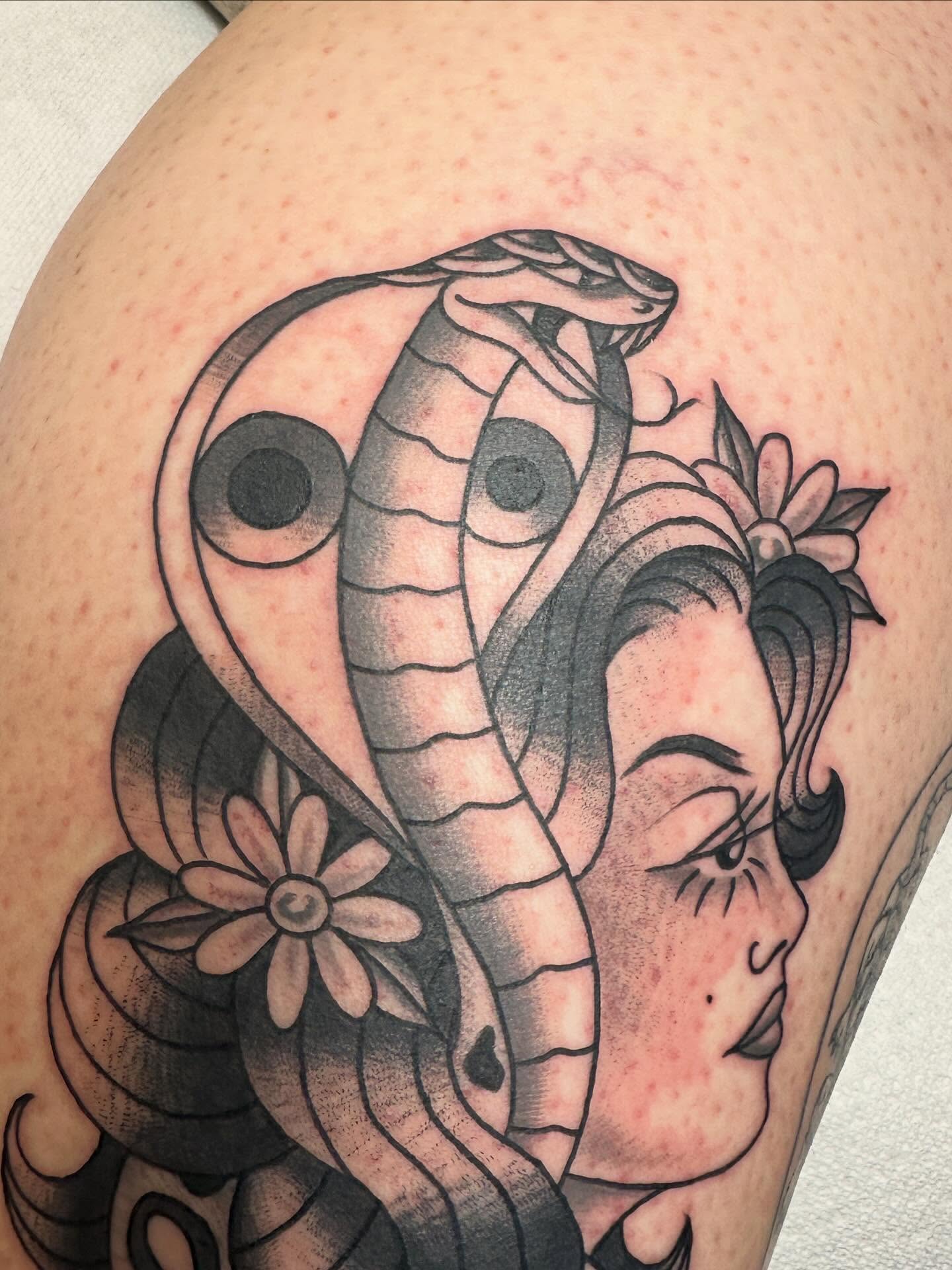 Woman with snake American traditional tattoo on the thigh by Hannah Eddy