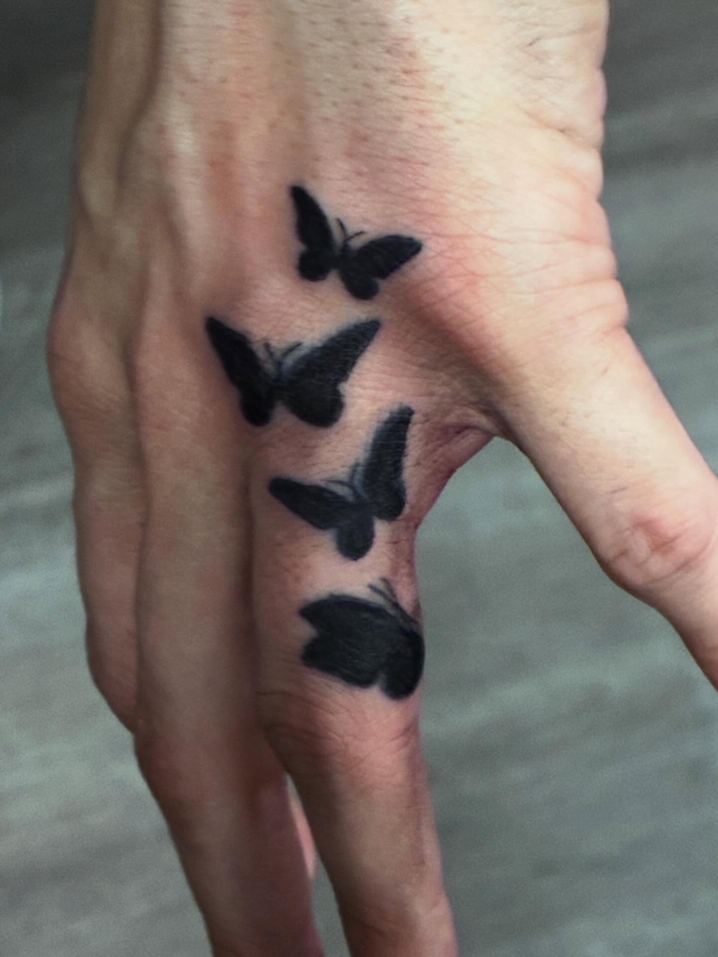 Butterflies black and grey tattoo on the hand by Trae