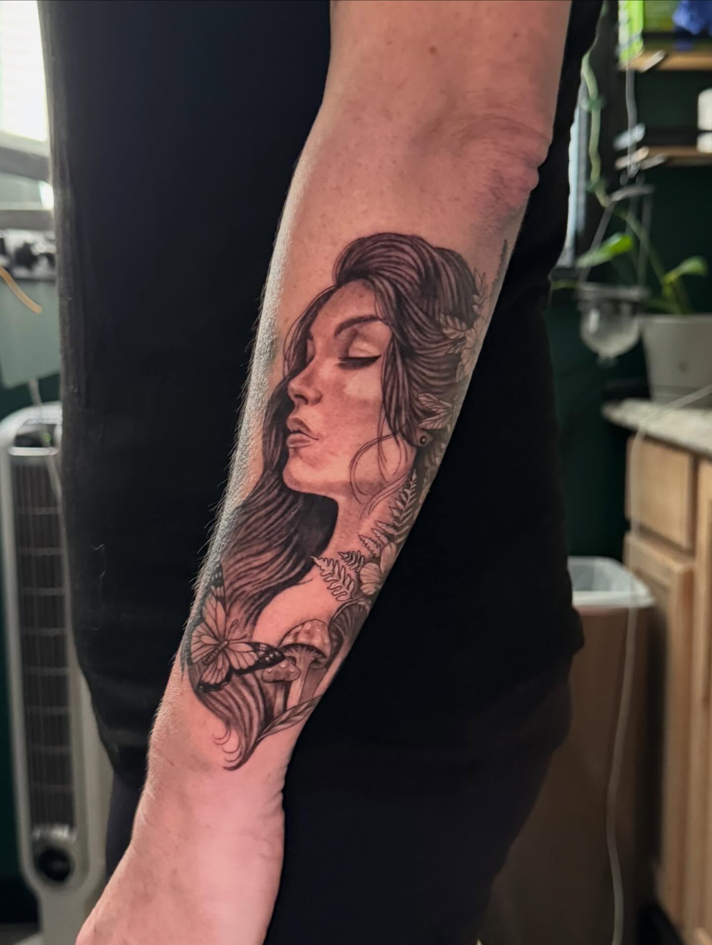 Woman with flowers realism tattoo on the forearm by Leslea Hipp