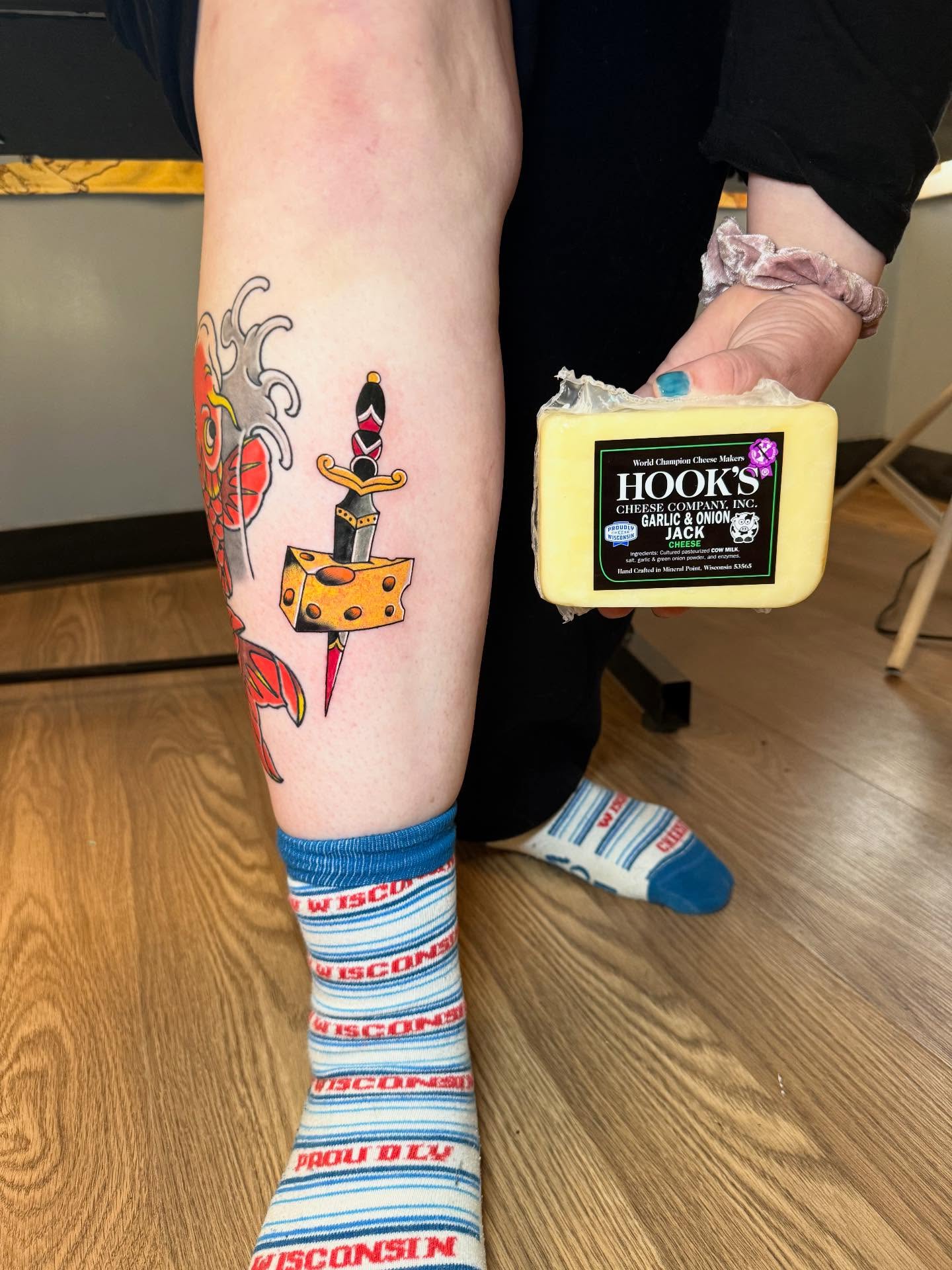 Cheese and knife American traditional tattoo on the leg by Max
