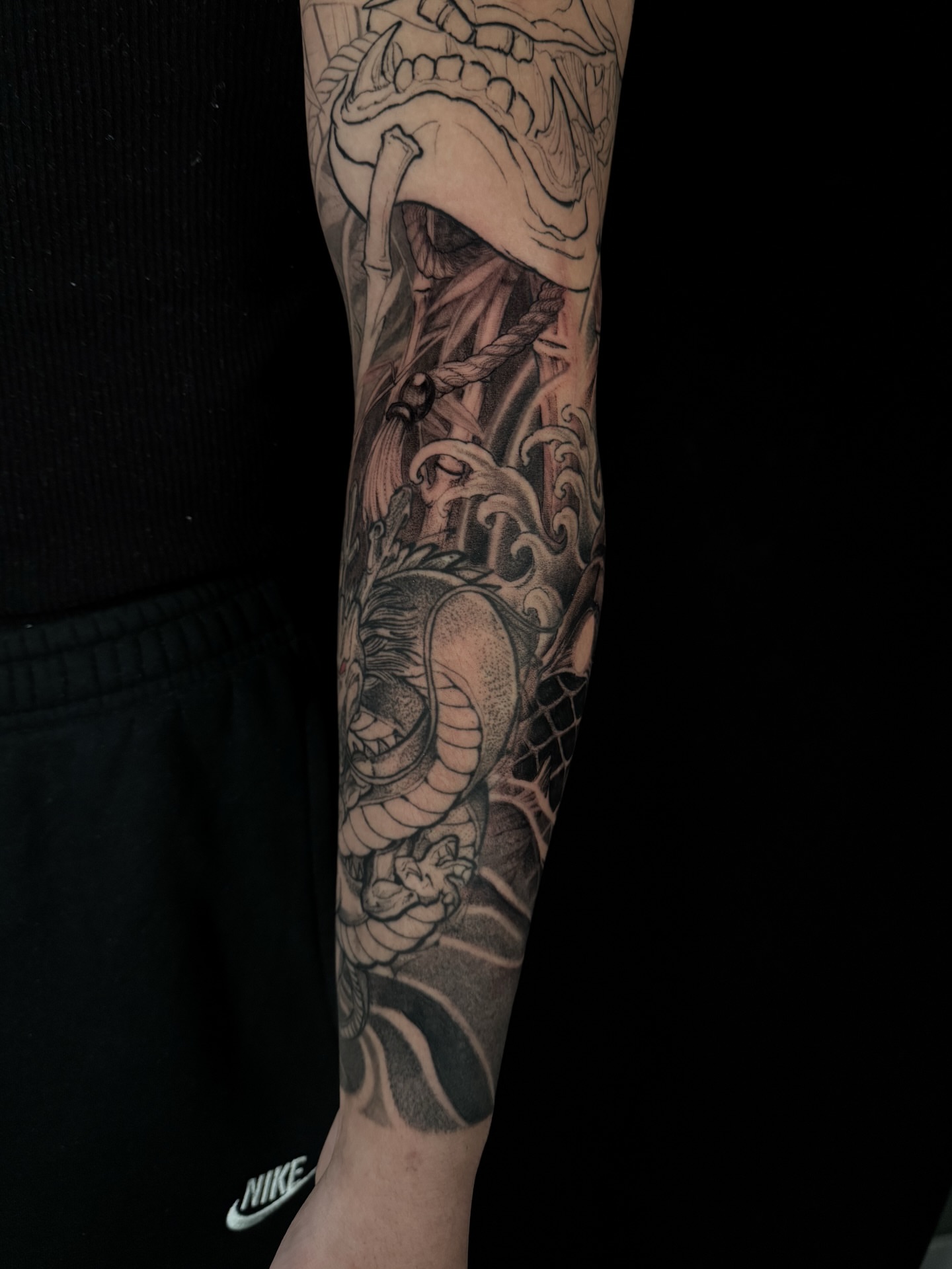 Snake and mask realism tattoo on the forearm by Vince Lau