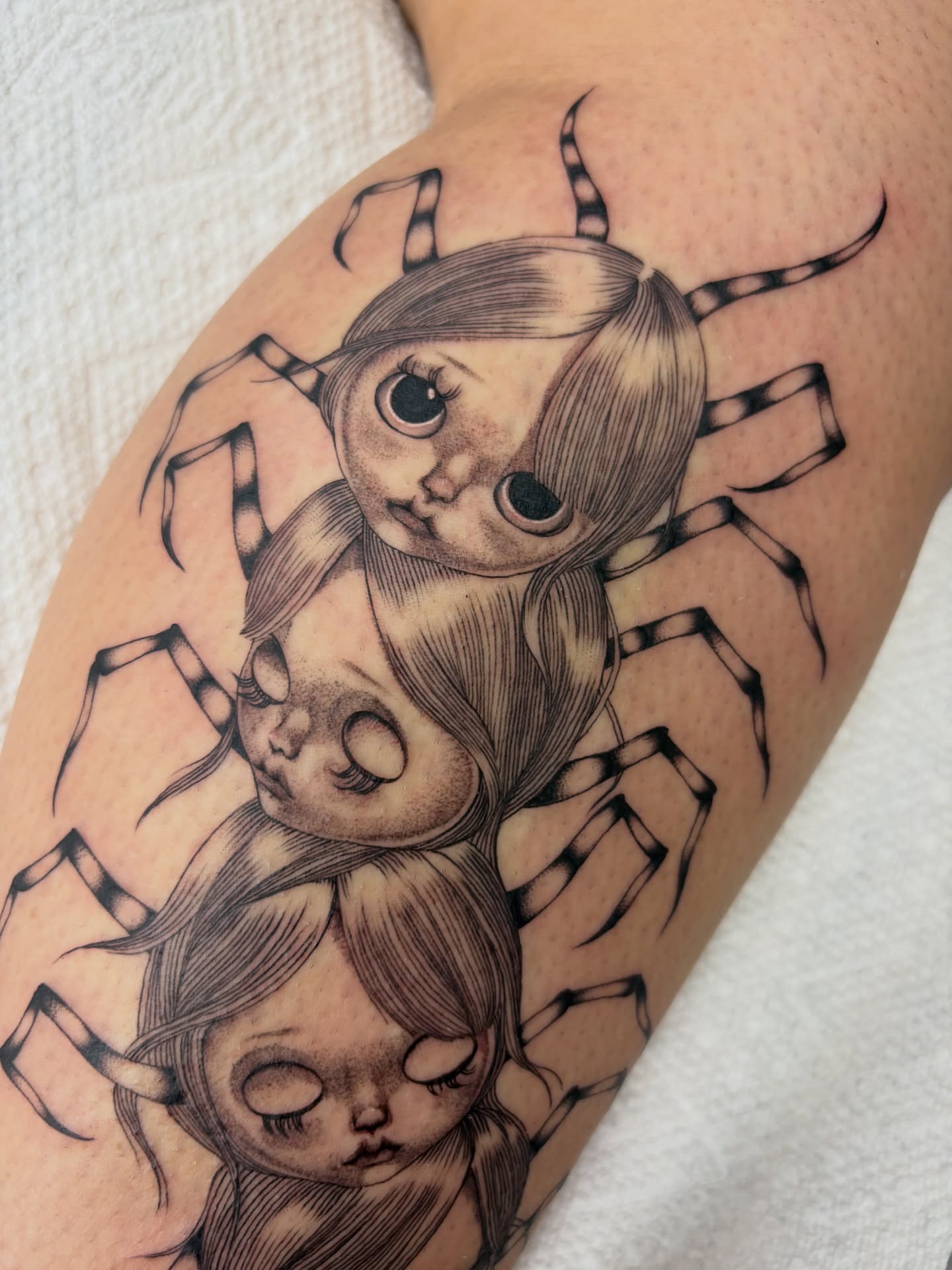 Spider dolls realism tattoo on the upper arm by Nori