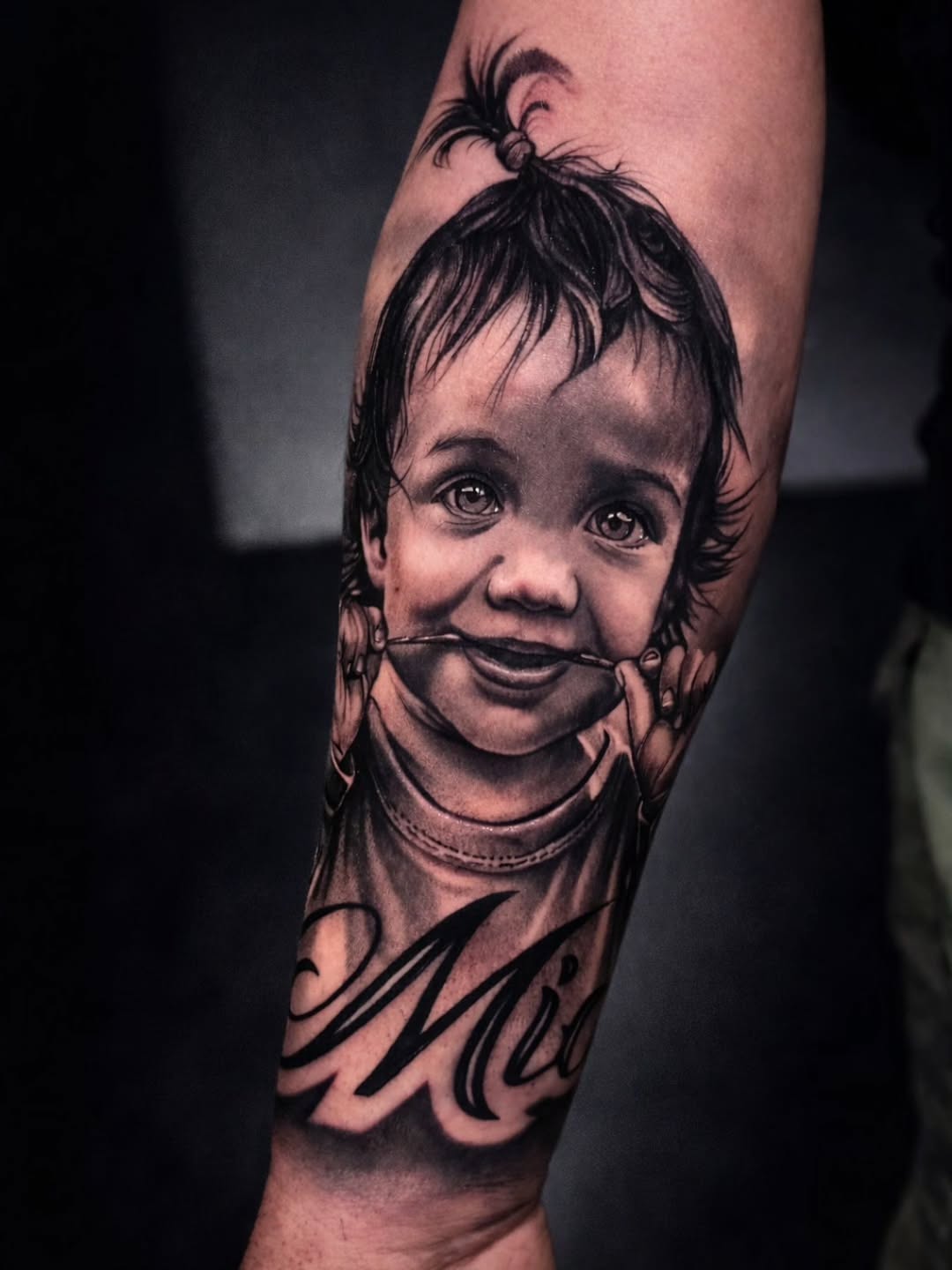 Baby portrait with name Chicano tattoo on the forearm by Lukasz Olszanski