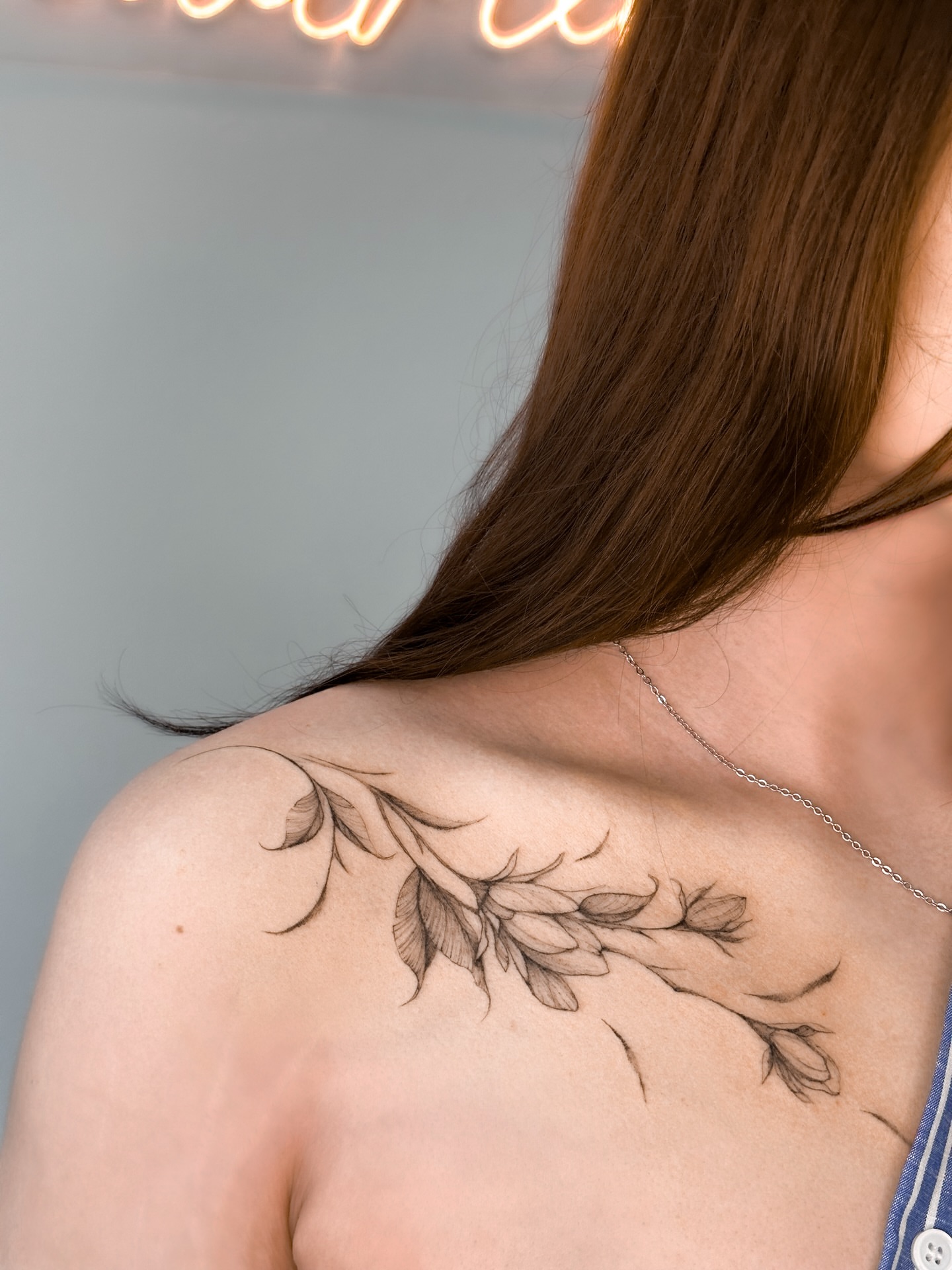 Branch with leaves black and grey tattoo on the shoulder by Mila, Riga, Latvia