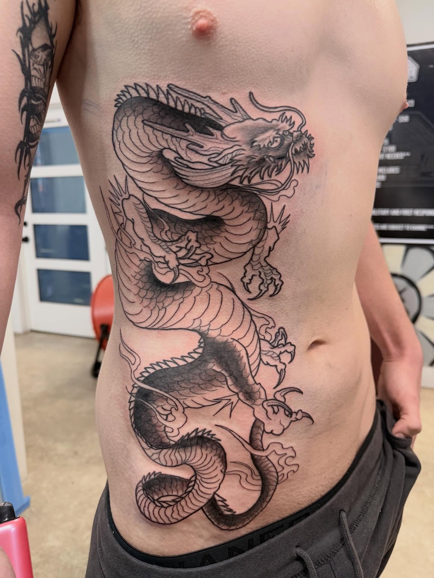 Dragon black and grey tattoo on the torso by H.G