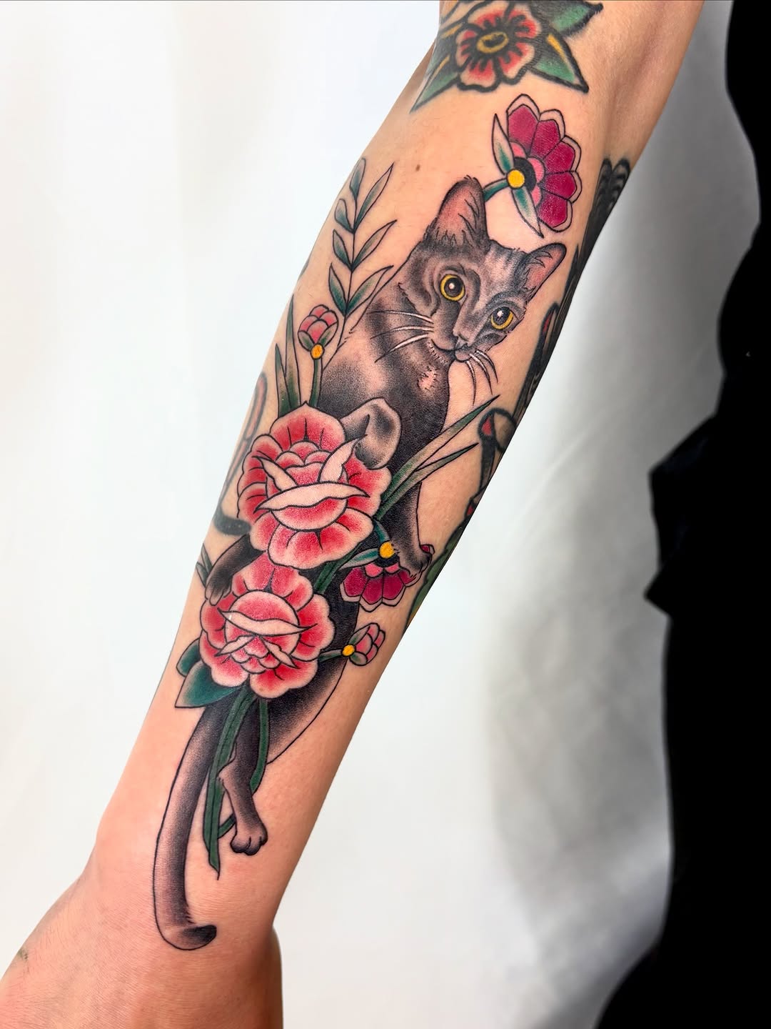Cat with flowers neo-traditional tattoo on the forearm by Bianca Cattapan
