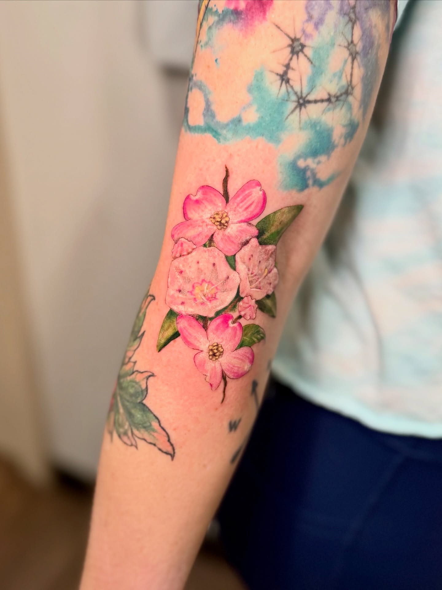 Cherry blossoms watercolor tattoo on the forearm by Tatum