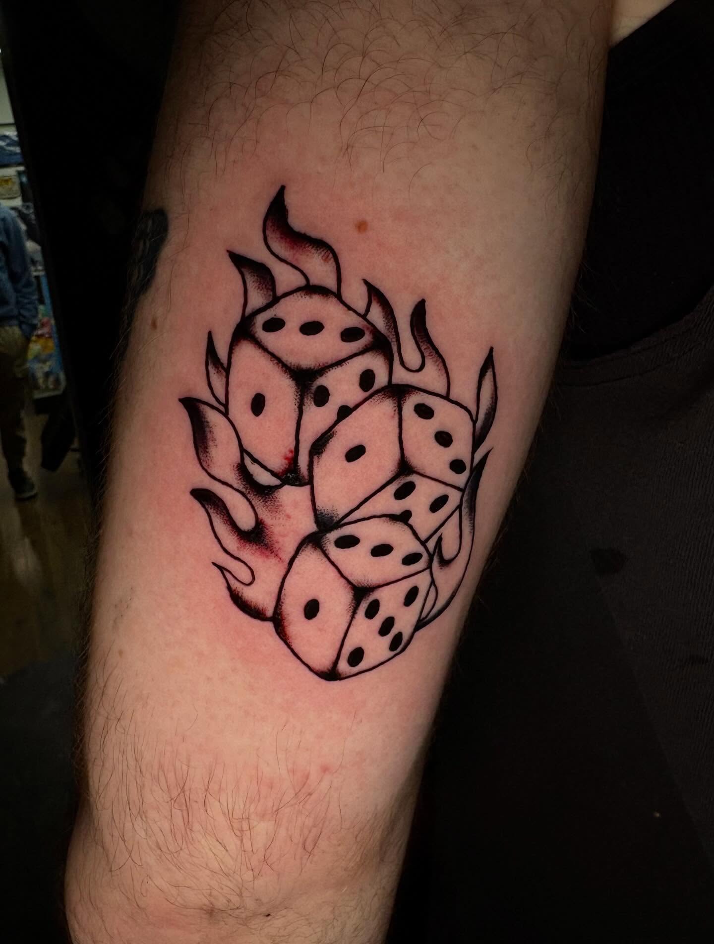 Dice black and grey tattoo on the forearm by Jenna Clayton