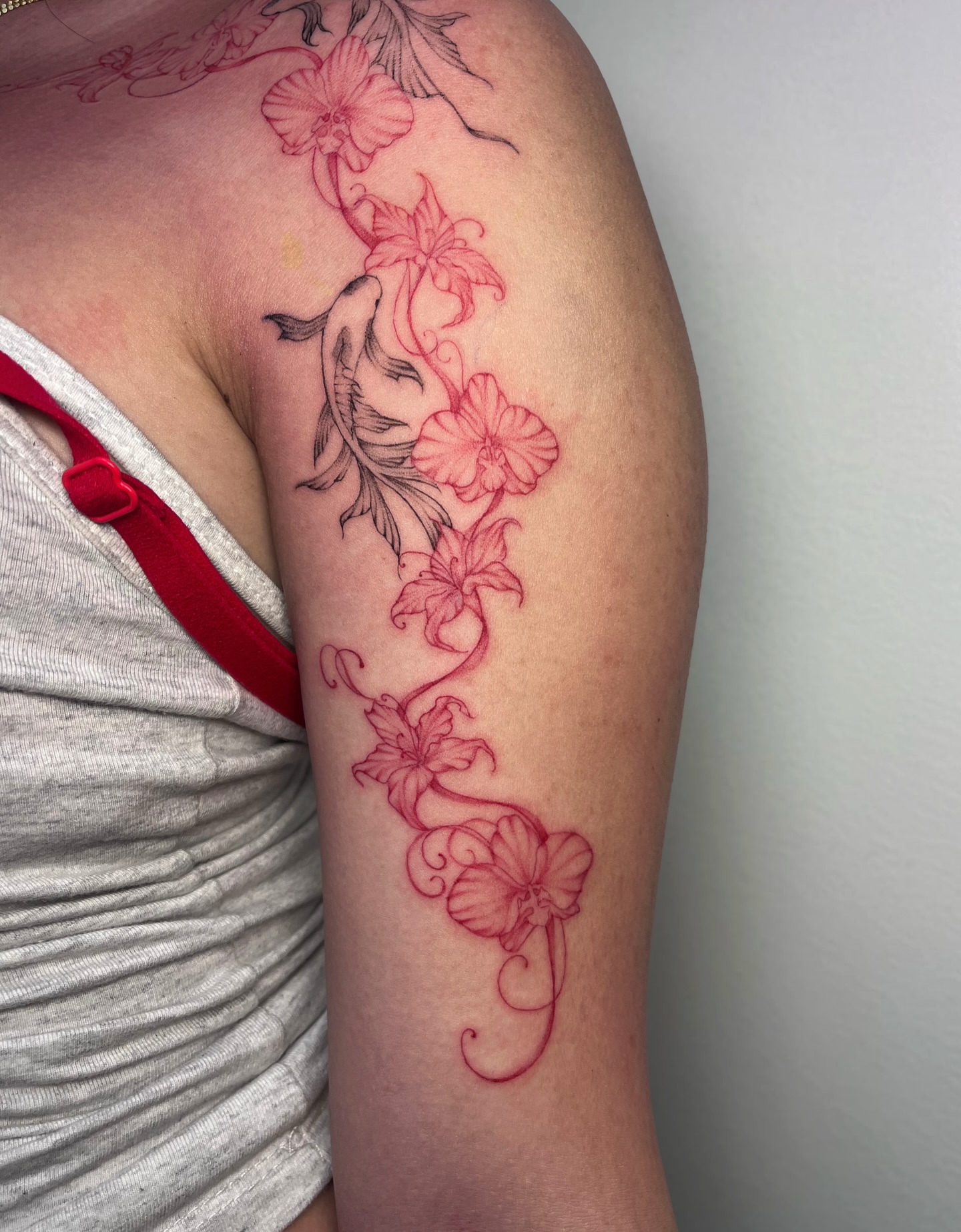 Floral vine fine line tattoo on the upper arm by MK