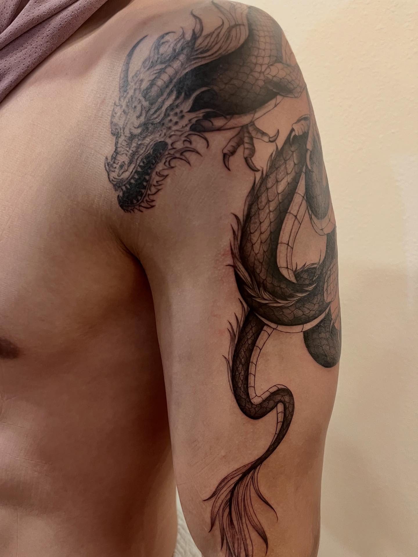 Dragon black and grey tattoo on the shoulder by Kite.Tattoo_Amber