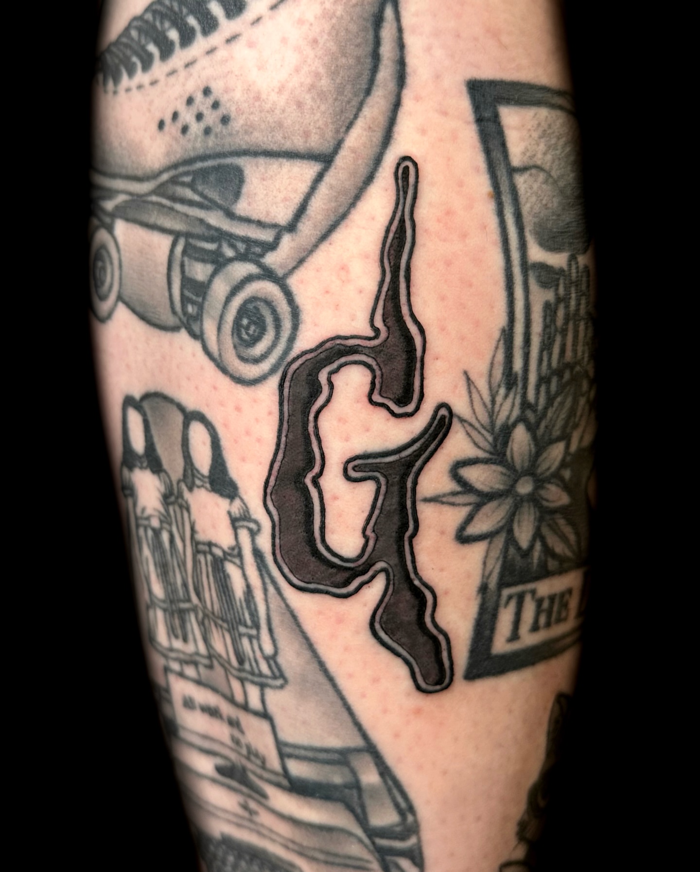 Skateboard and floral American traditional tattoo on the forearm by Nick Bones, Las Vegas, Nevada