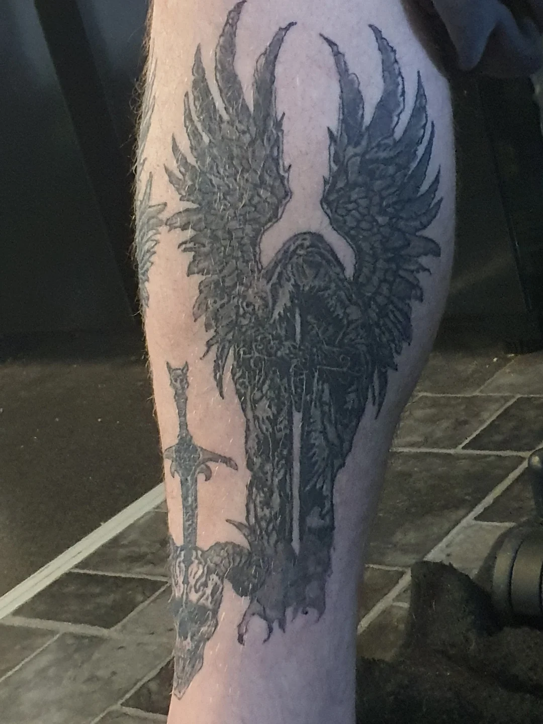 Wings and dragon black and grey tattoo on the forearm by Artful Ink