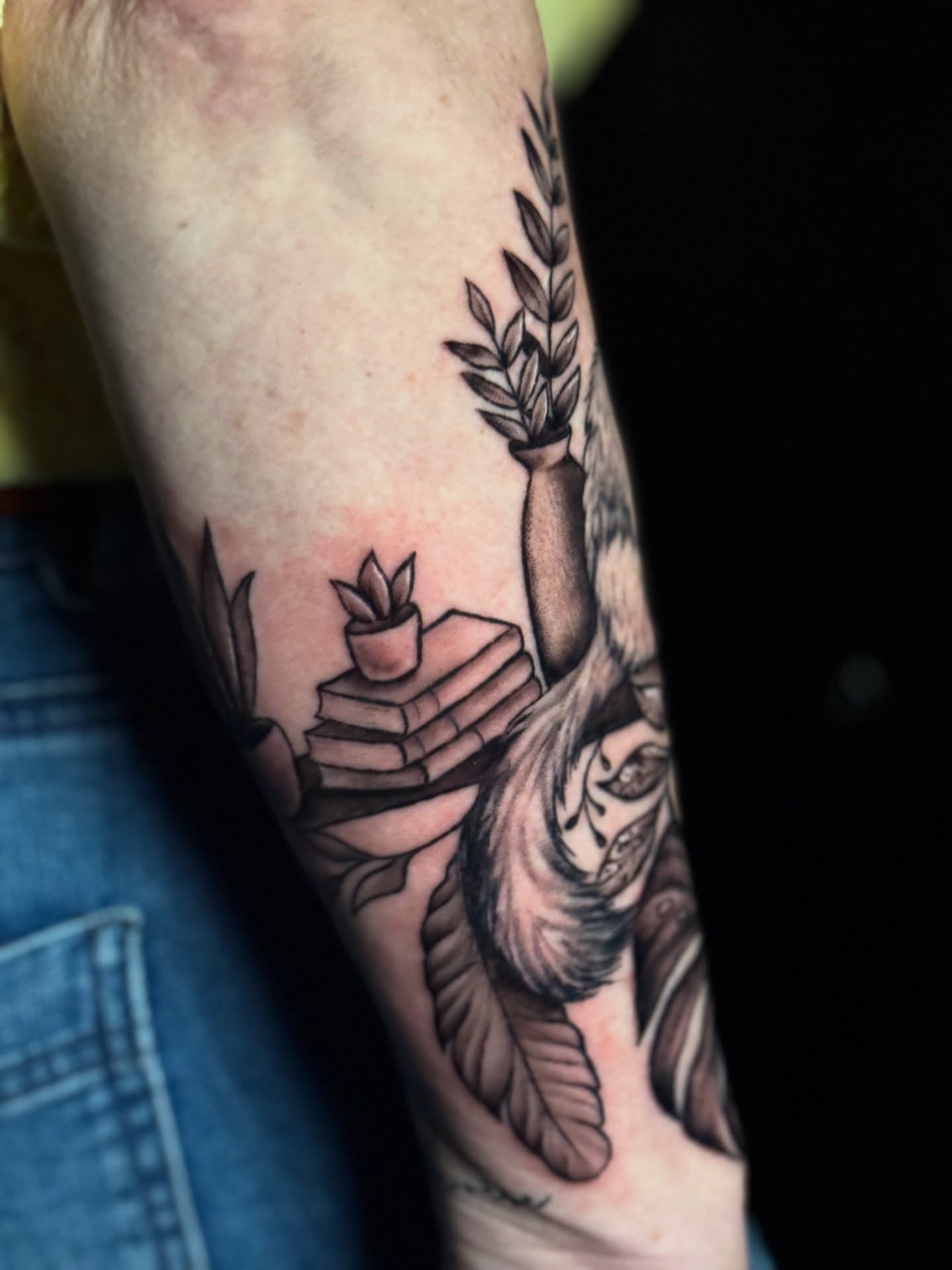Books and plant black and grey tattoo on the forearm by Lily Bejarno