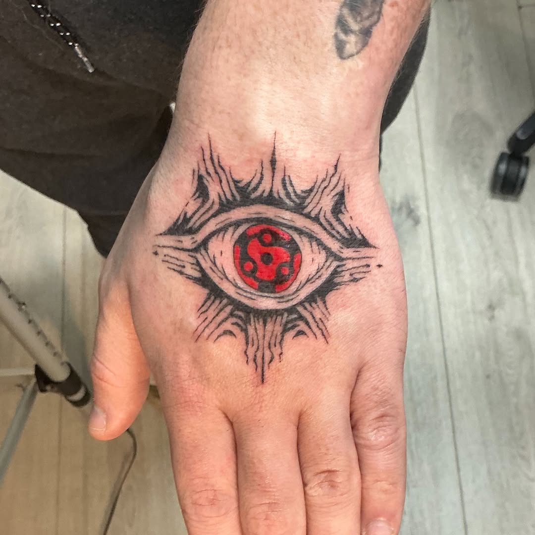Sharingan eye anime tattoo on the hand by Isaac Mccavitt
