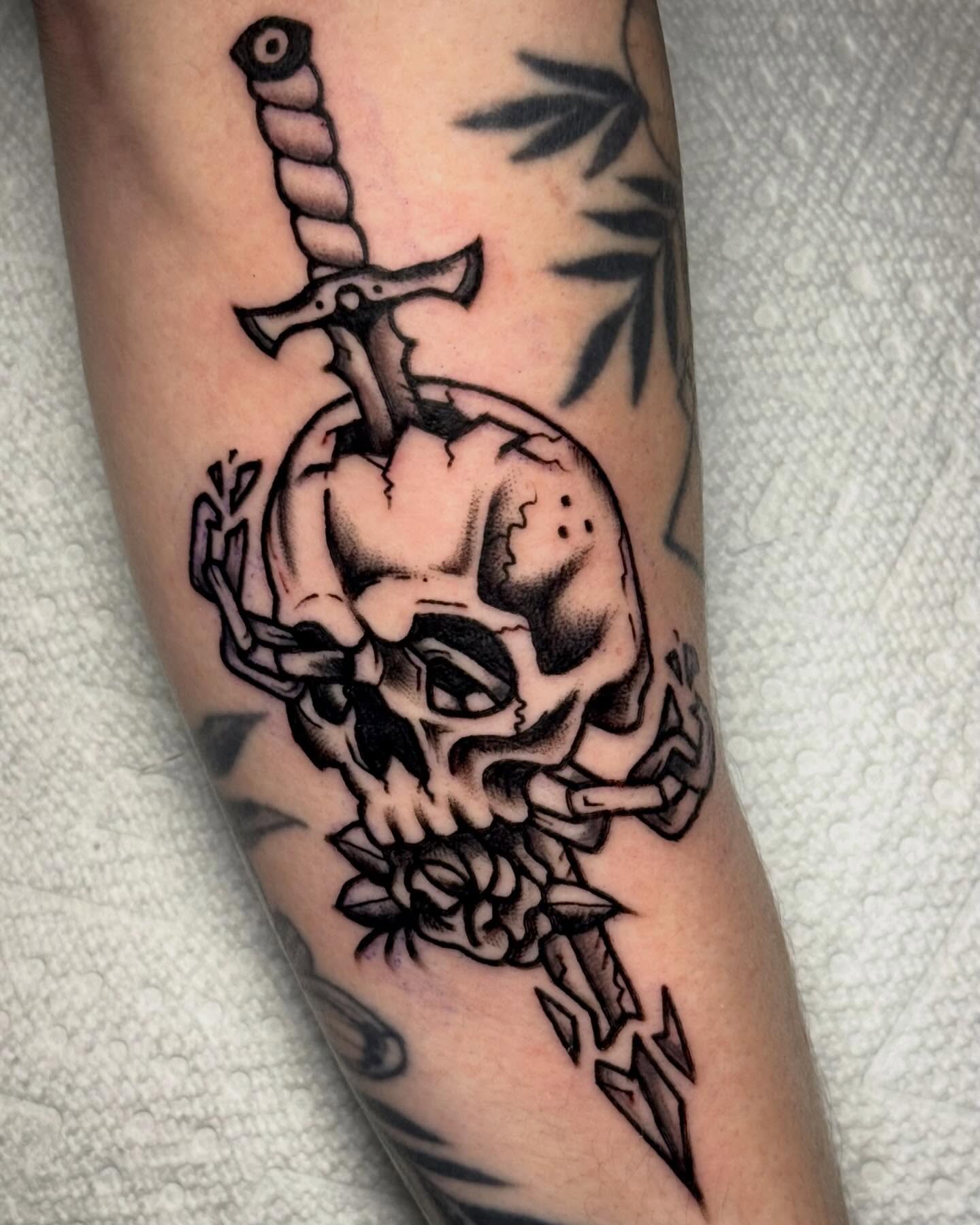 Skull and sword realism tattoo on the forearm by Ty Elias