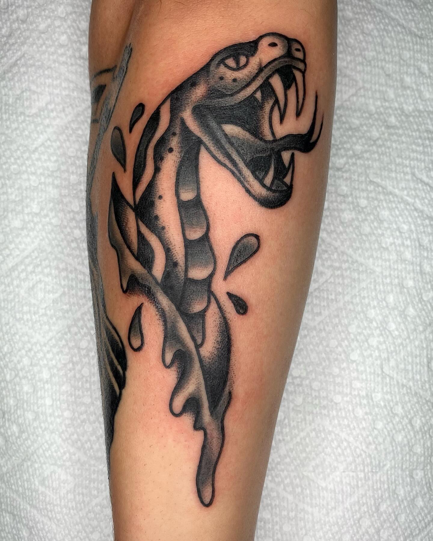 Snake black and grey tattoo on the forearm by Ty Elias