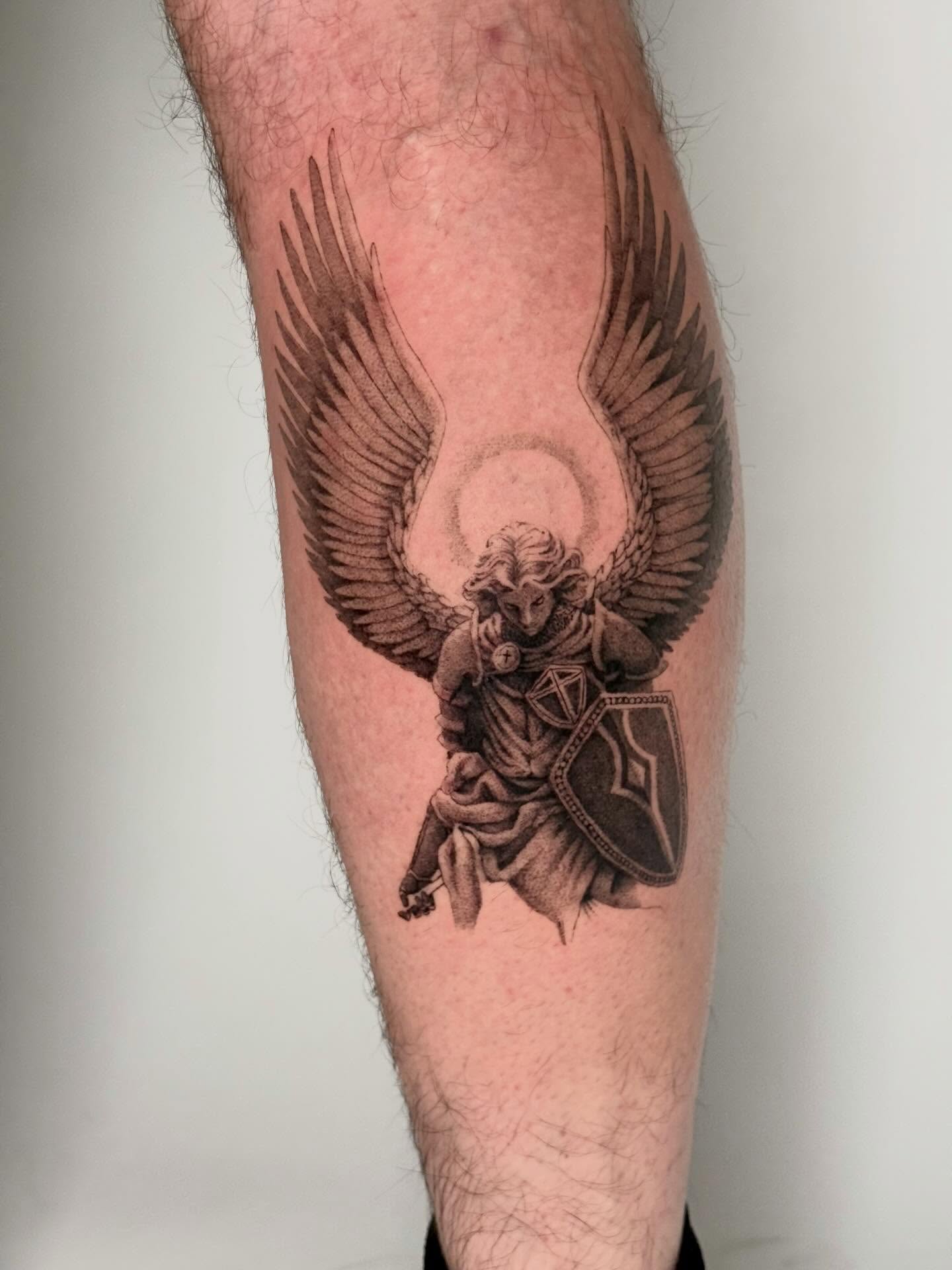 Angel with shield black and grey tattoo on the forearm by Andrew Flatts