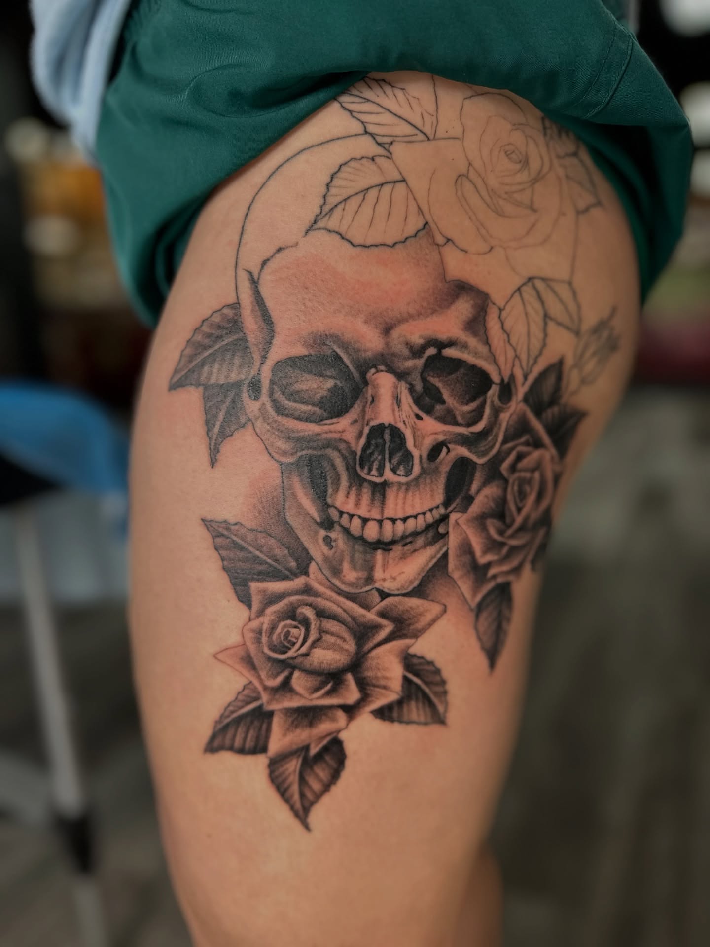 Skull and roses realism tattoo on the thigh by Skoty Fox