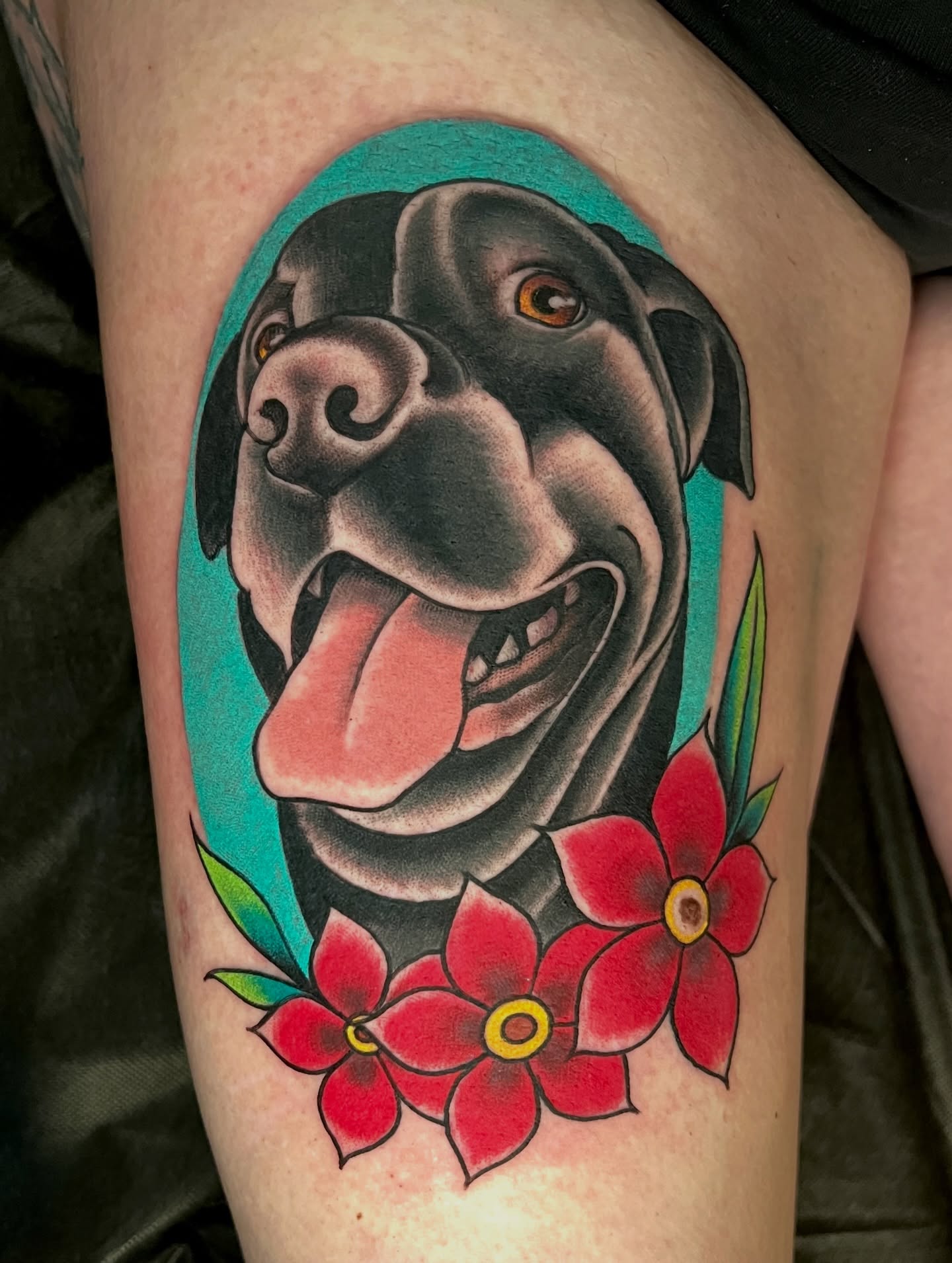 Dog with flowers American traditional tattoo on the thigh by JoshUA Bowers, Des Moines, Iowa