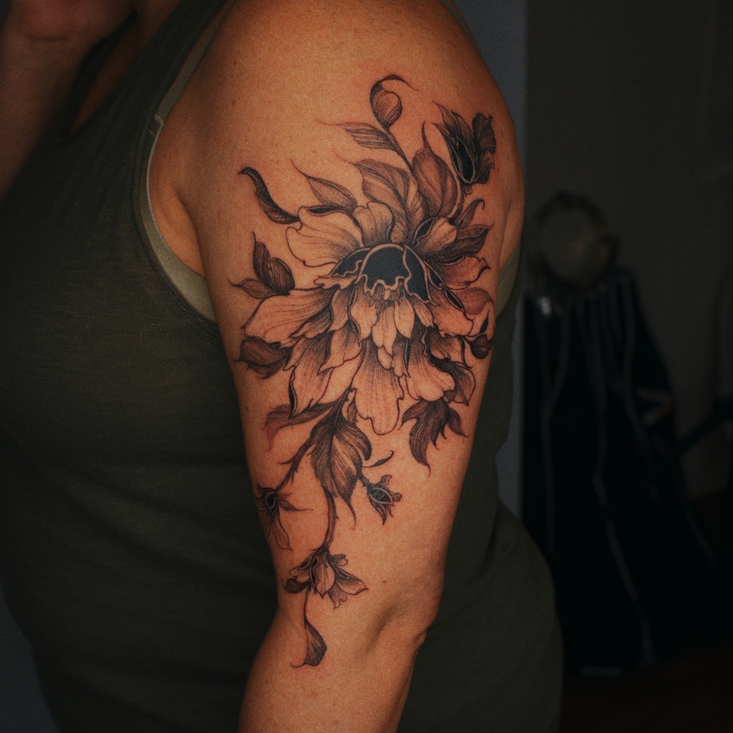 Floral arrangement black and grey tattoo on the upper arm by Brad Simmons