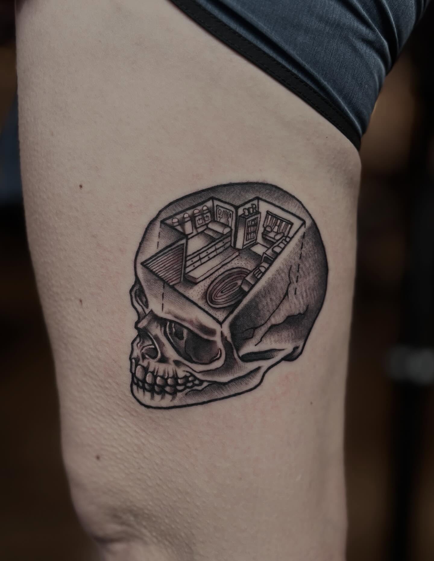 Skull with radio black and grey tattoo on the thigh by Mim