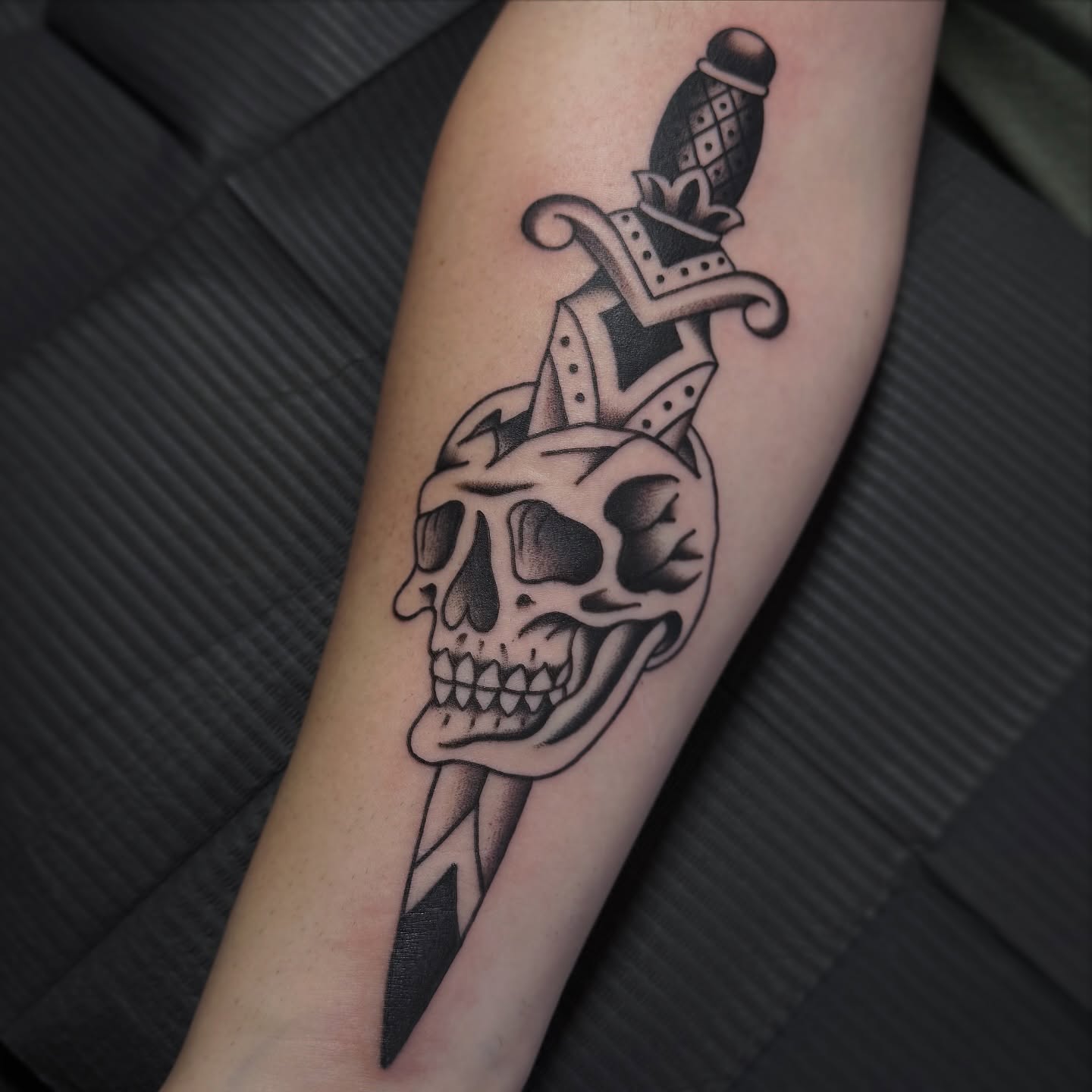 Skull and dagger black and grey tattoo on the forearm by Kaley, Des Moines, Iowa