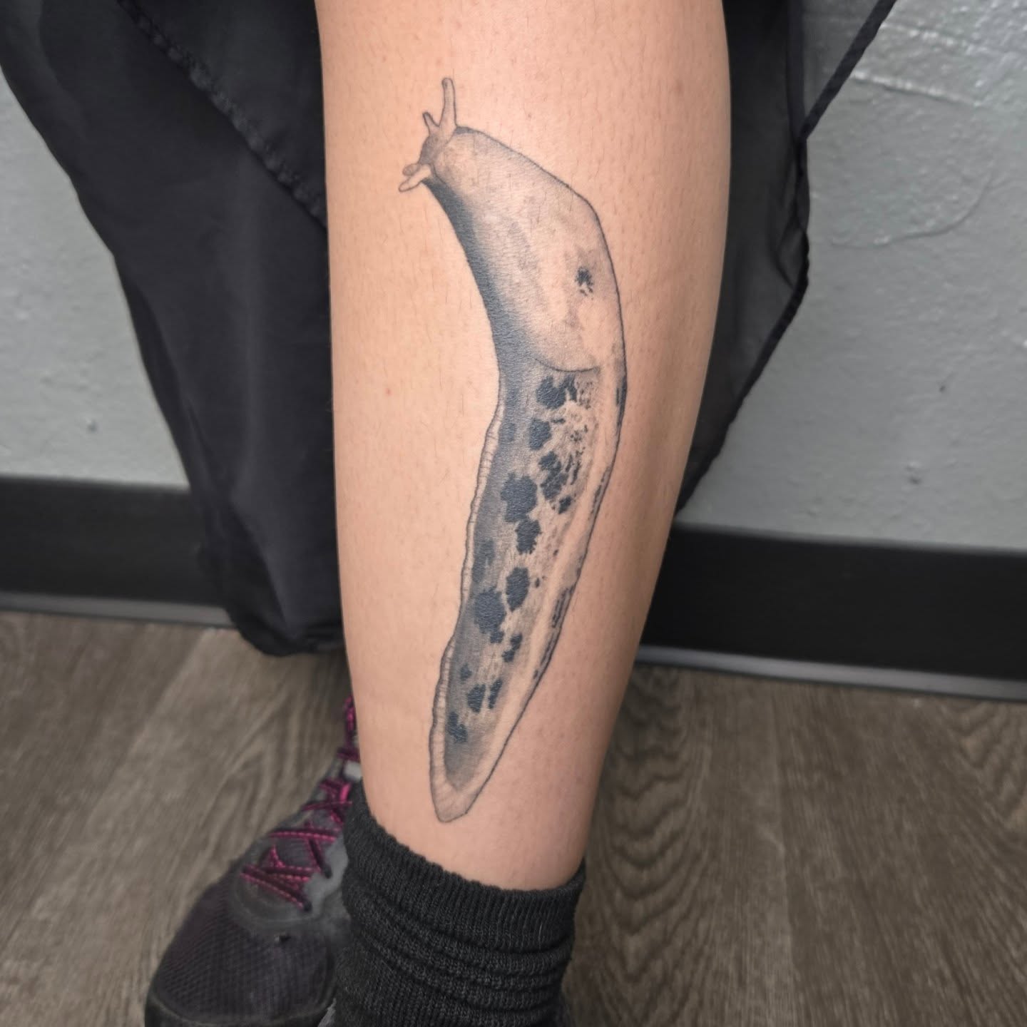 Slug black and grey tattoo on the calf by alec