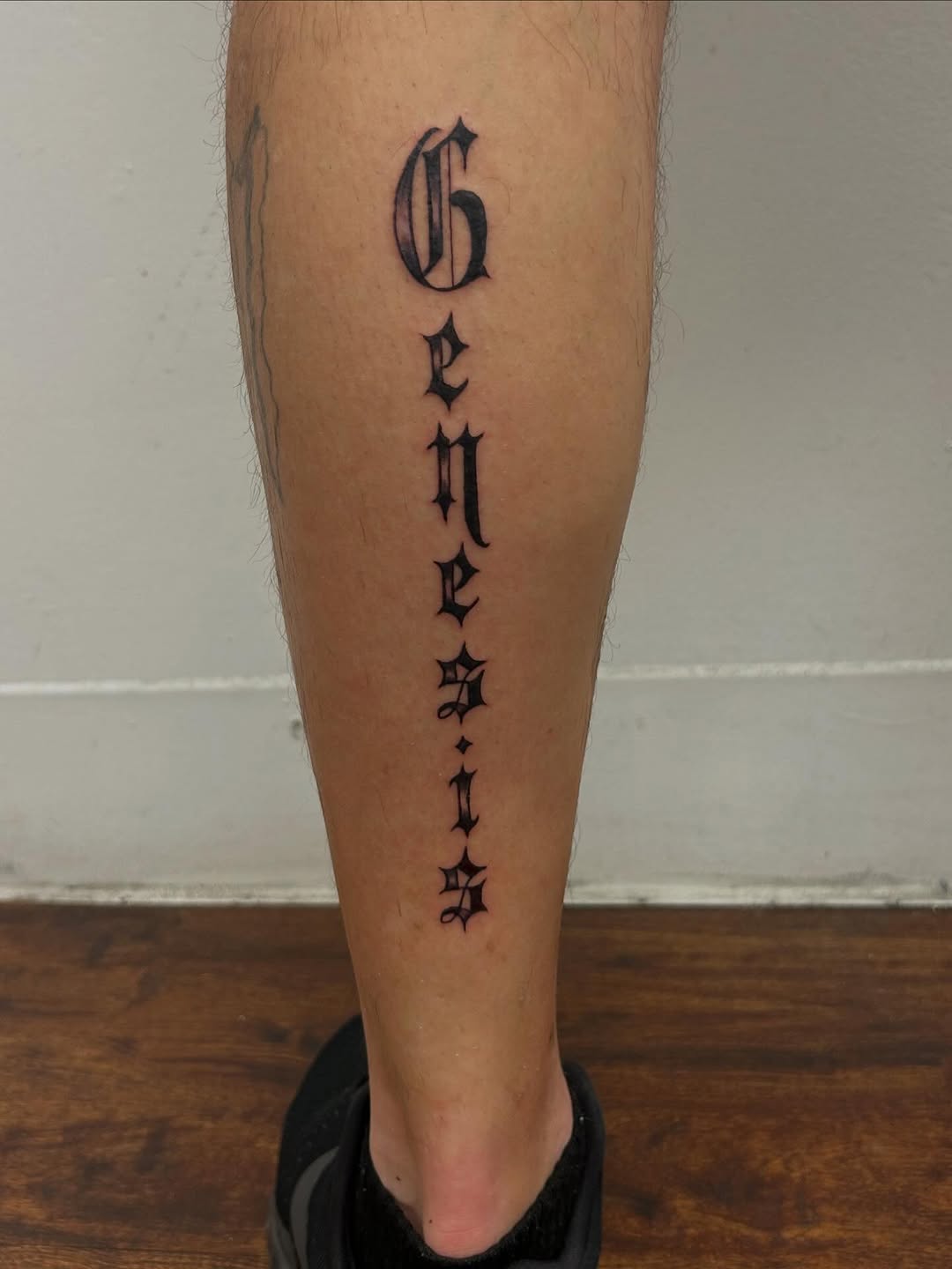 Genesis lettering lettering tattoo on the calf by Chris