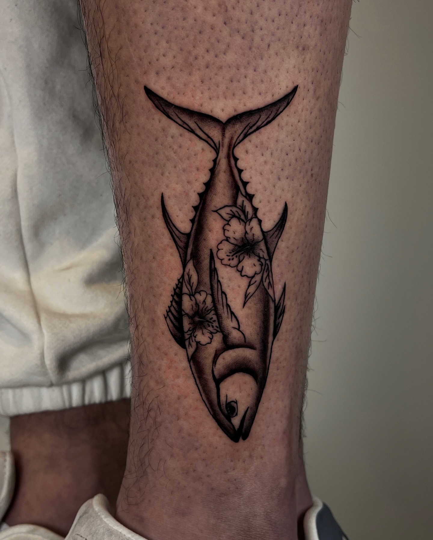 Tuna with floral patterns black and grey tattoo on the forearm by Rebel milly Tattoo