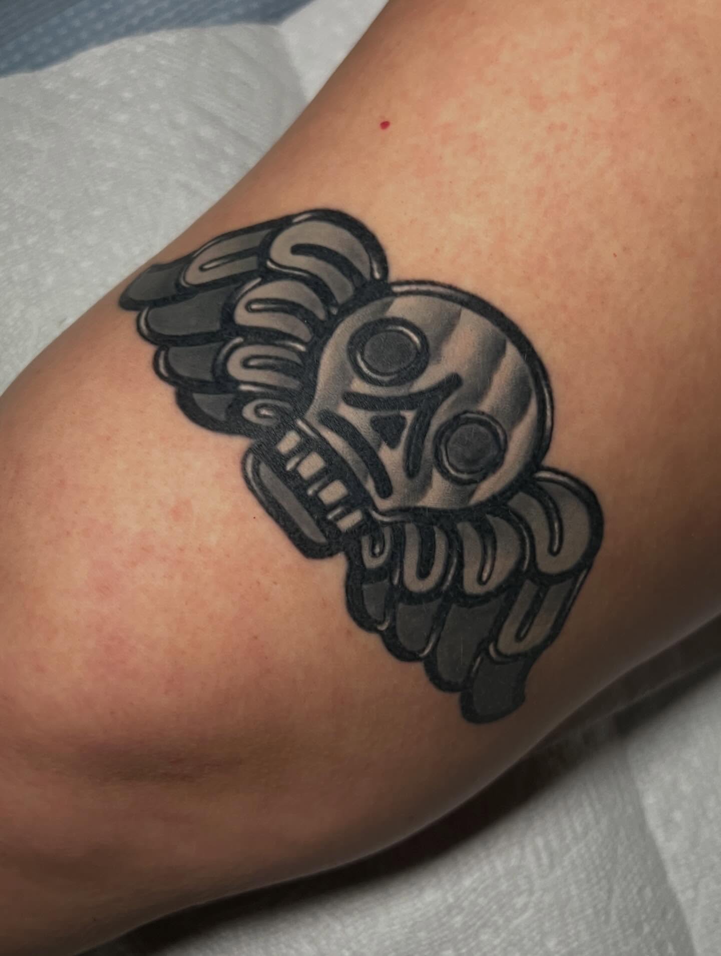 Skull with wings black and grey tattoo on the forearm by Katie Ann Tattoos
