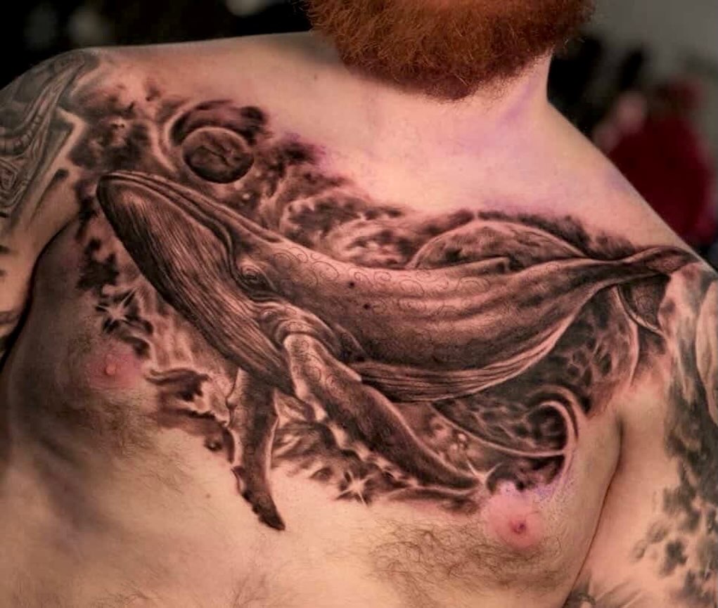 Humpback whale in space fine line tattoo on the chest by Comfy Chris Fettig
