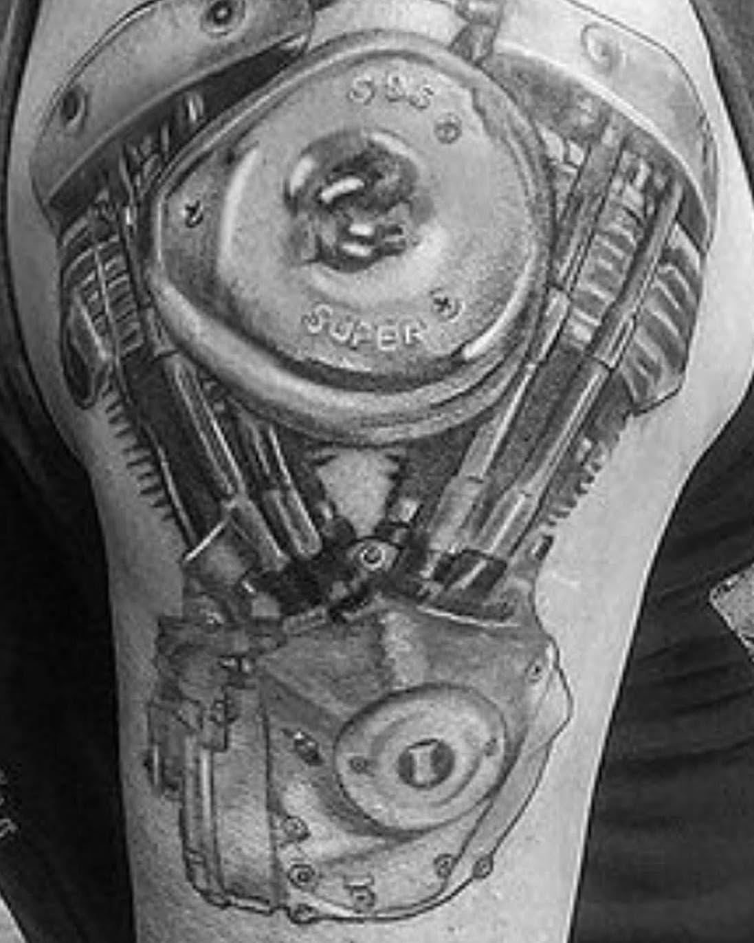 Mechanical engine black and grey tattoo on the upper arm by Léon Huiting