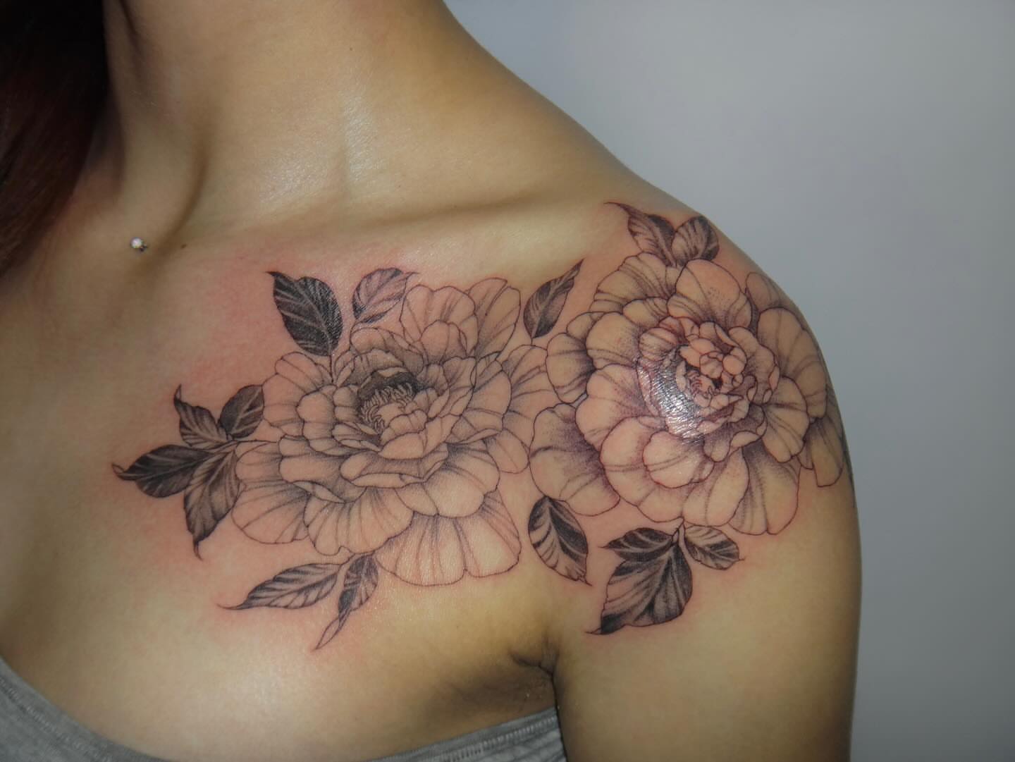 Flowers black and grey tattoo on the shoulder by Nevaeh tattoo artist