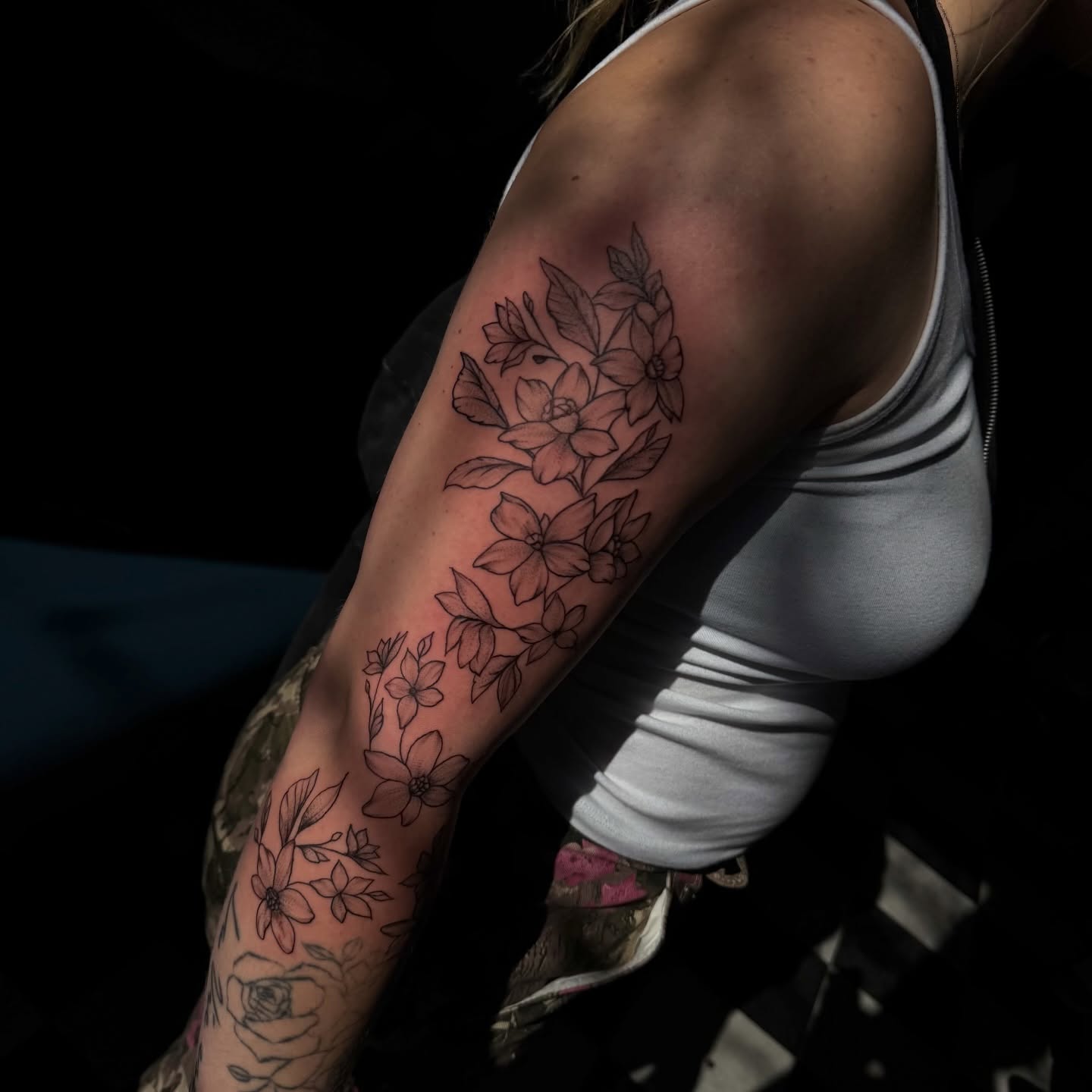 Floral arrangement black and grey tattoo on the upper arm by Nina Nichole