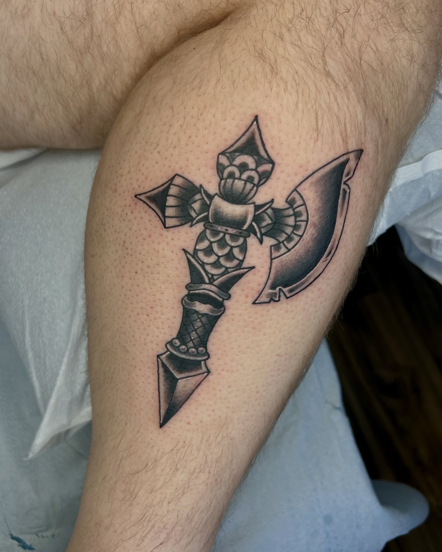 Sword and shield black and grey tattoo on the forearm by Noah Crow