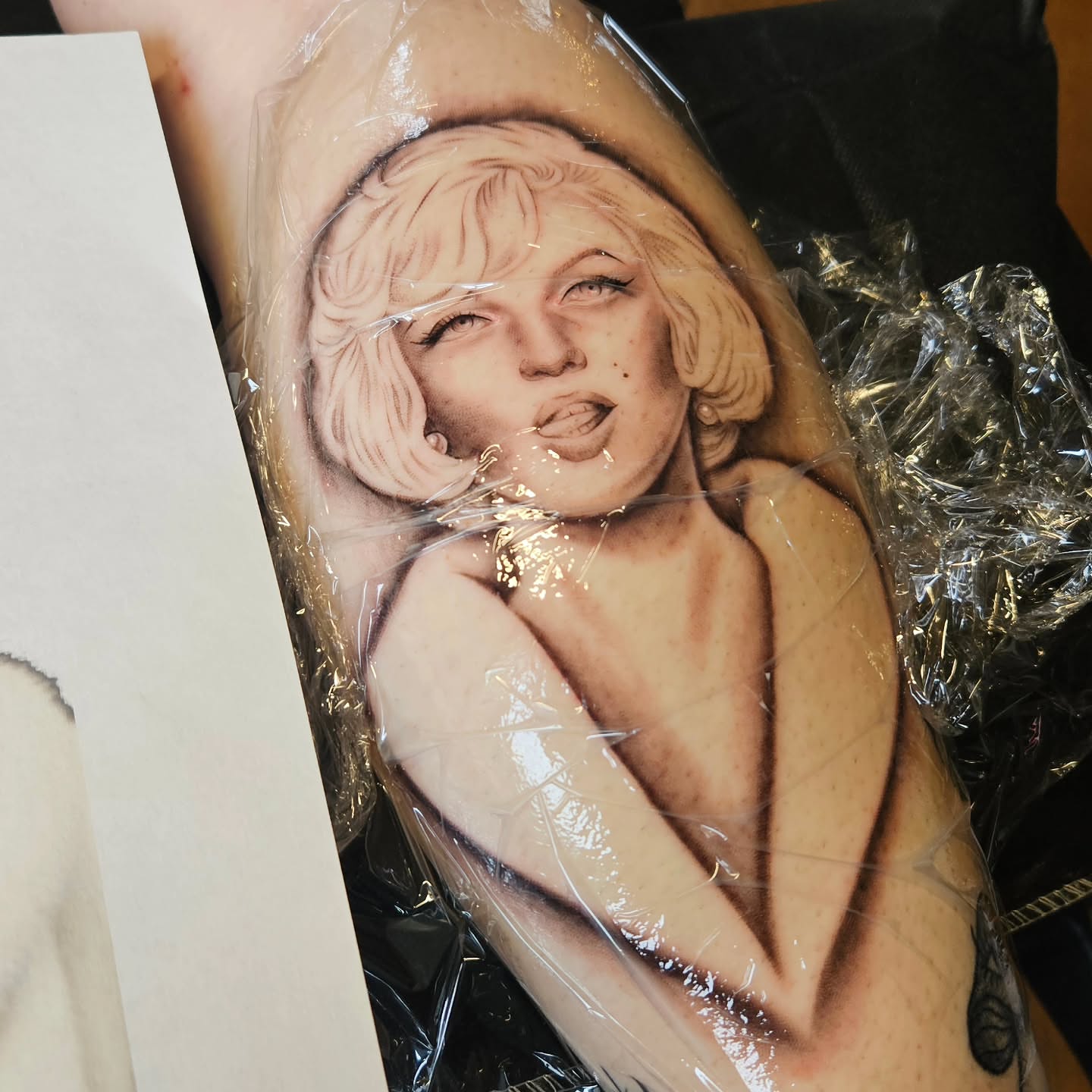 Naked woman realism tattoo on the upper arm by Courtlyn Bliss