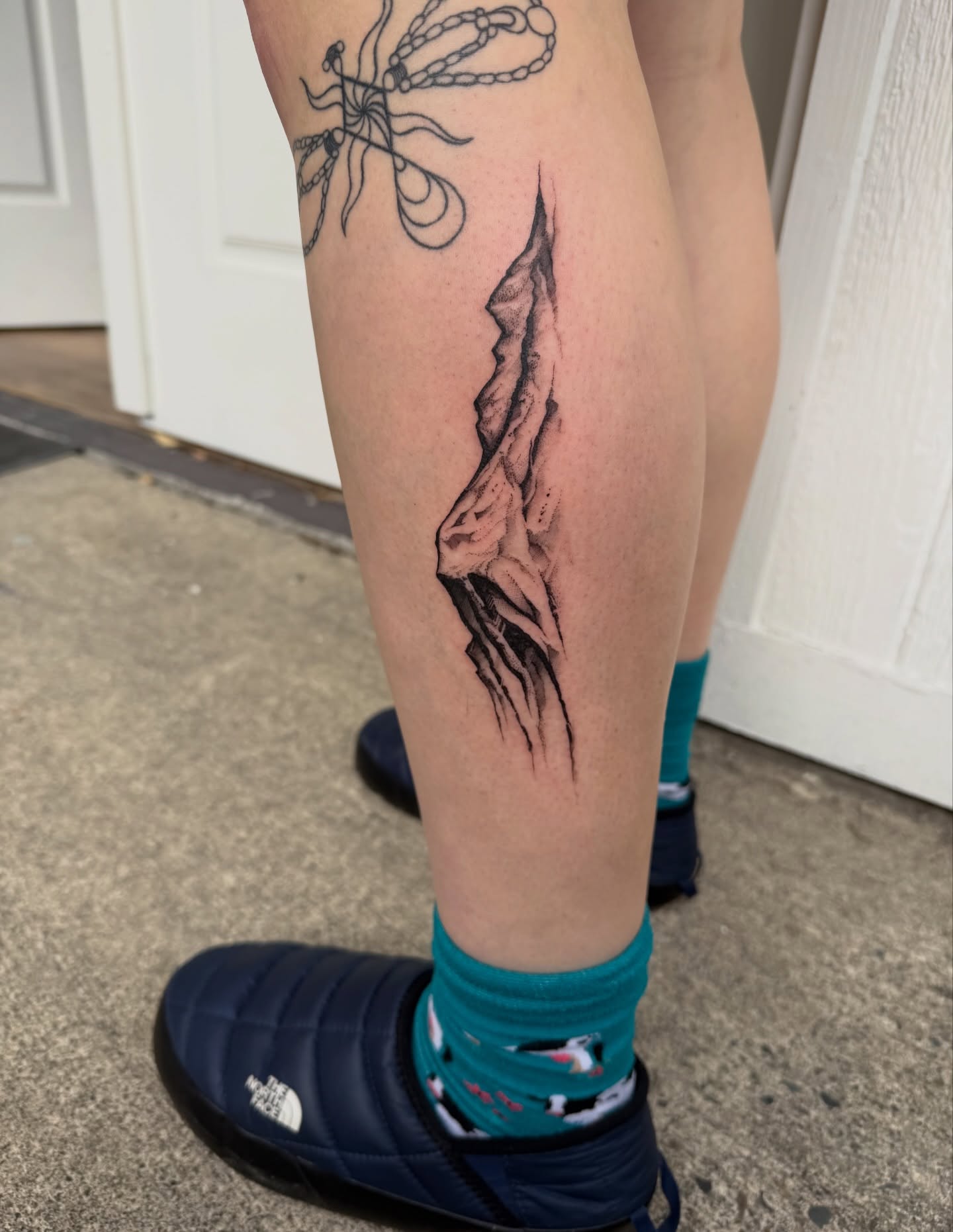 Cliff dotwork tattoo on the calf by Kingtide Ink